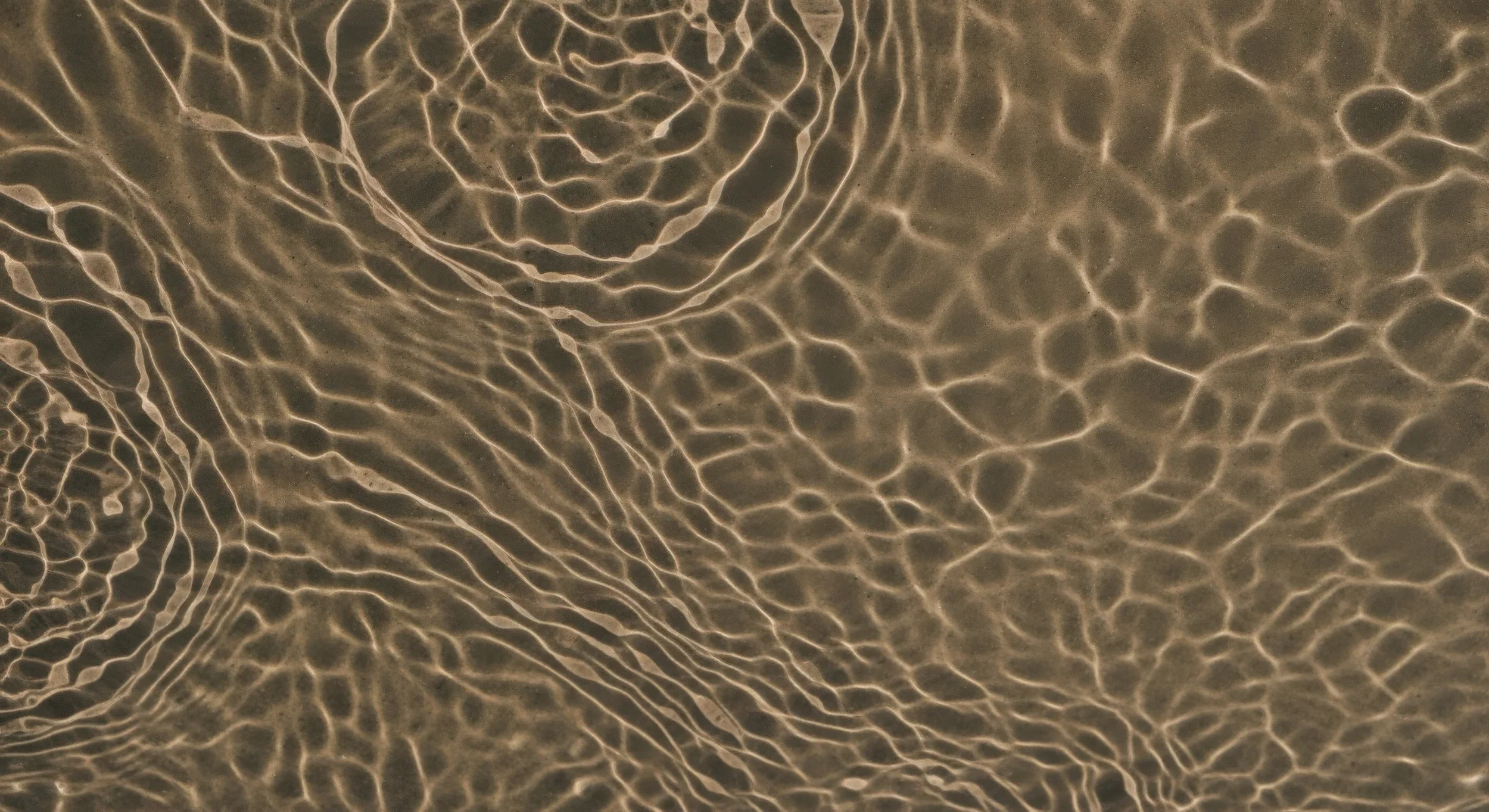 Light reflections on water creating intricate, wave-like patterns.