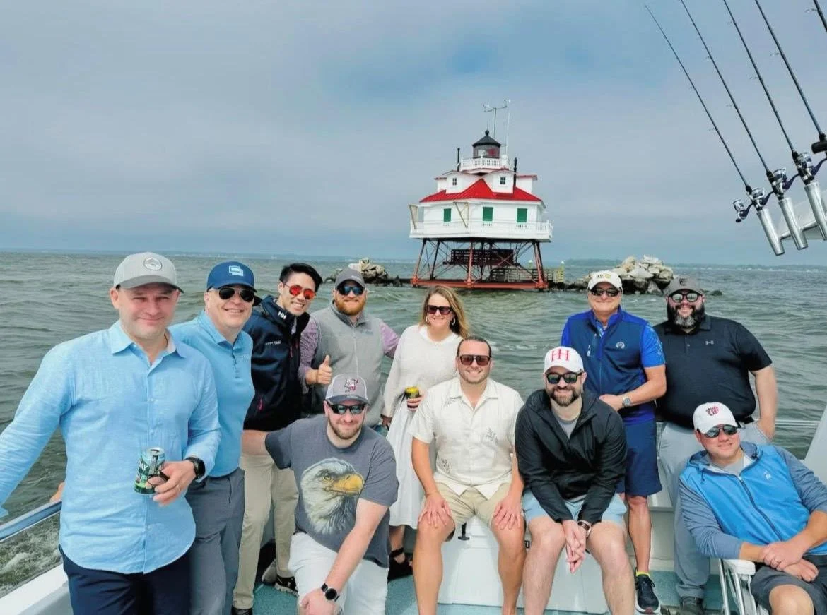 Group of people on a boat with a lighthouse in the background
