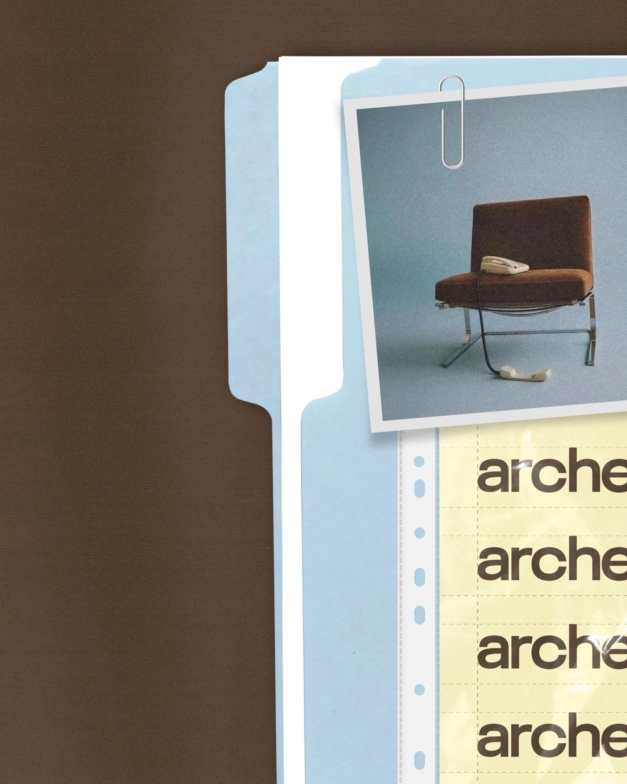 A close-up of a section of a filing cabinet or binder with blue and white dividers, a colored photo of a chair with a landline phone on it clipped to the top, and some printed text reading "arche."