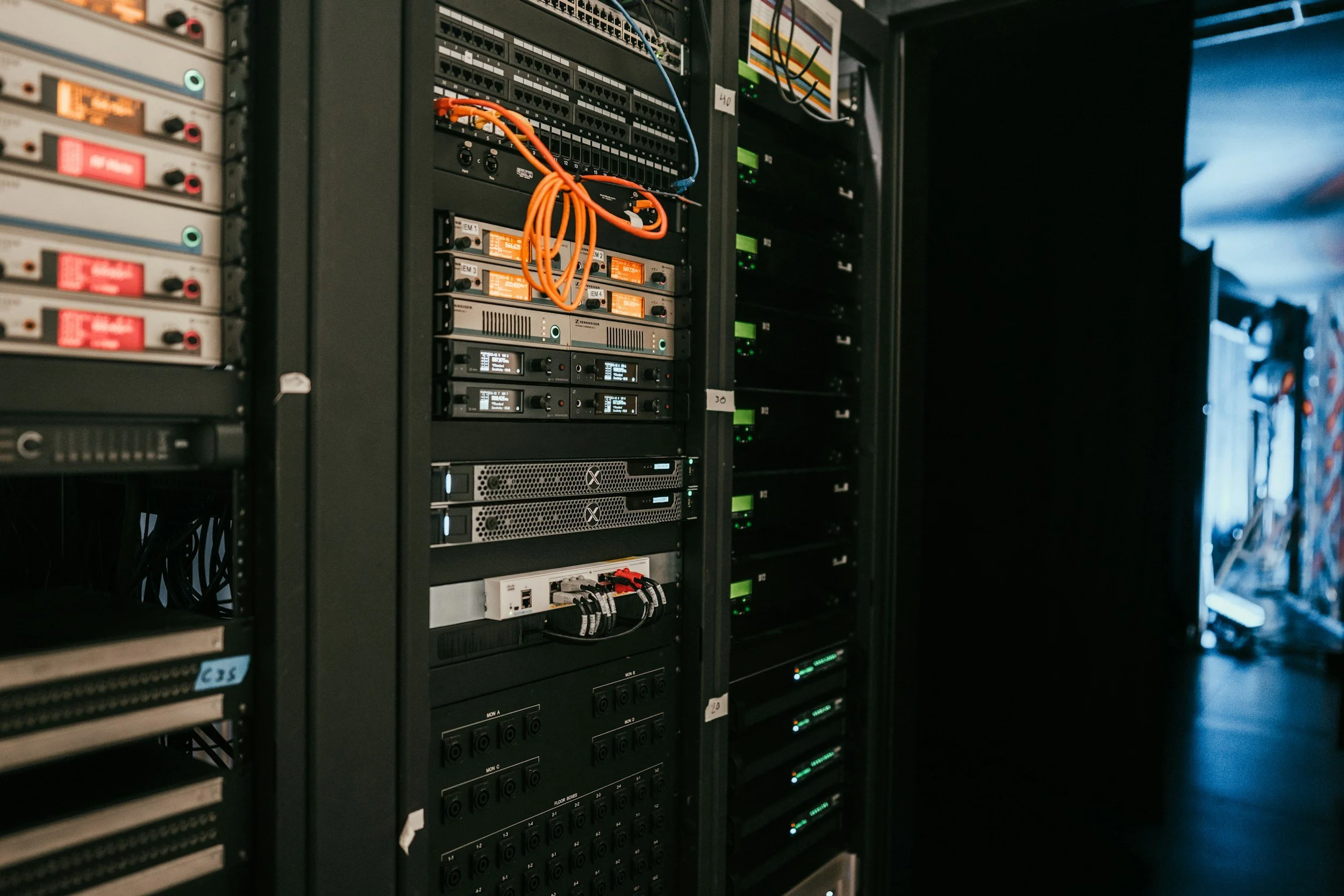 Server racks with networking equipment, cables, and switches in a data center.