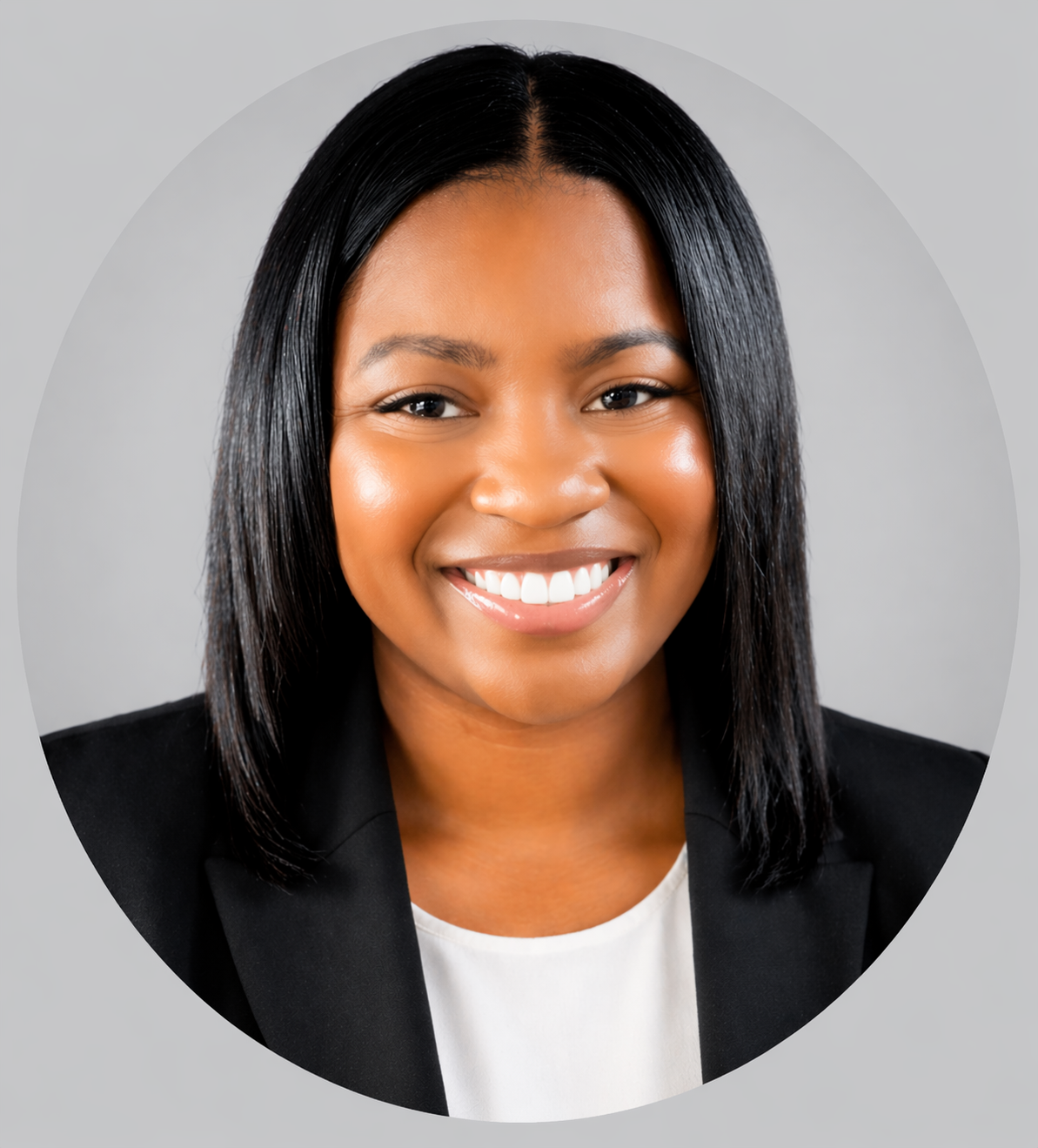 Headshot of a woman with shoulder-length black hair smiling, wearing a black blazer and white top, against a light gray background.