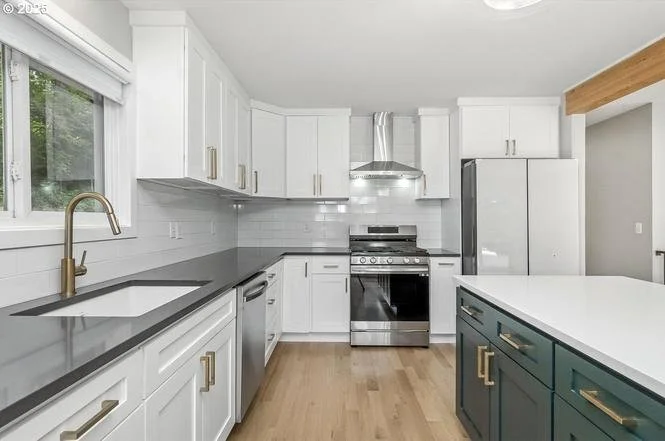 Refinished kitchen cabinets in a Beaverton home: white uppers with painted dark blue island, cabinet refinishing by Cascade Painting