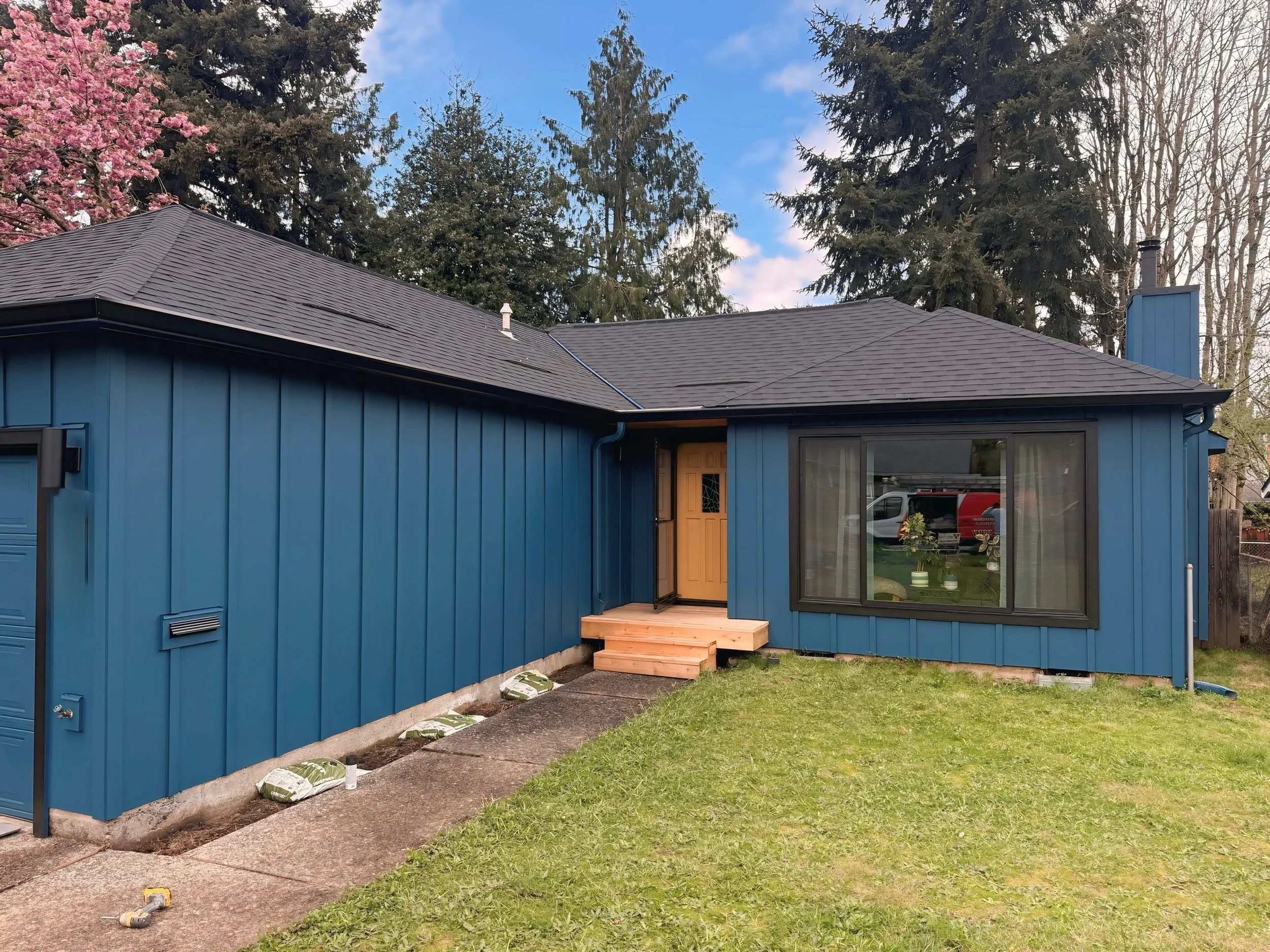 Beaverton home with freshly painted blue siding and stained wooden porch, exterior project by Cascade Painting