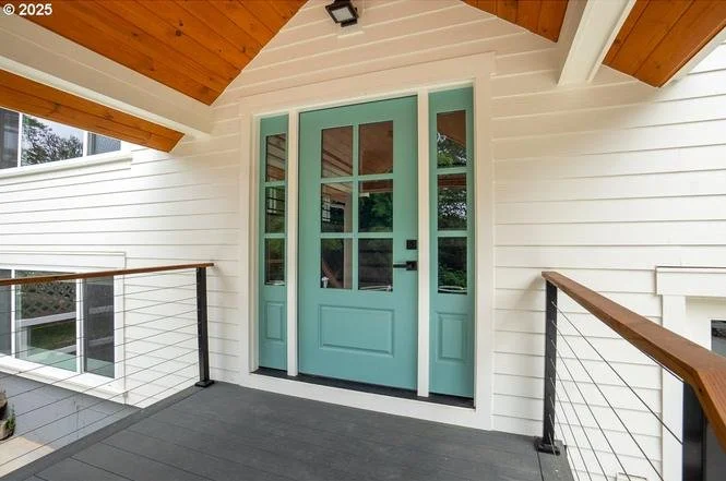Front porch with light blue door, white siding, and stained wood ceiling, custom exterior color work by Cascade Painting in Beaverton