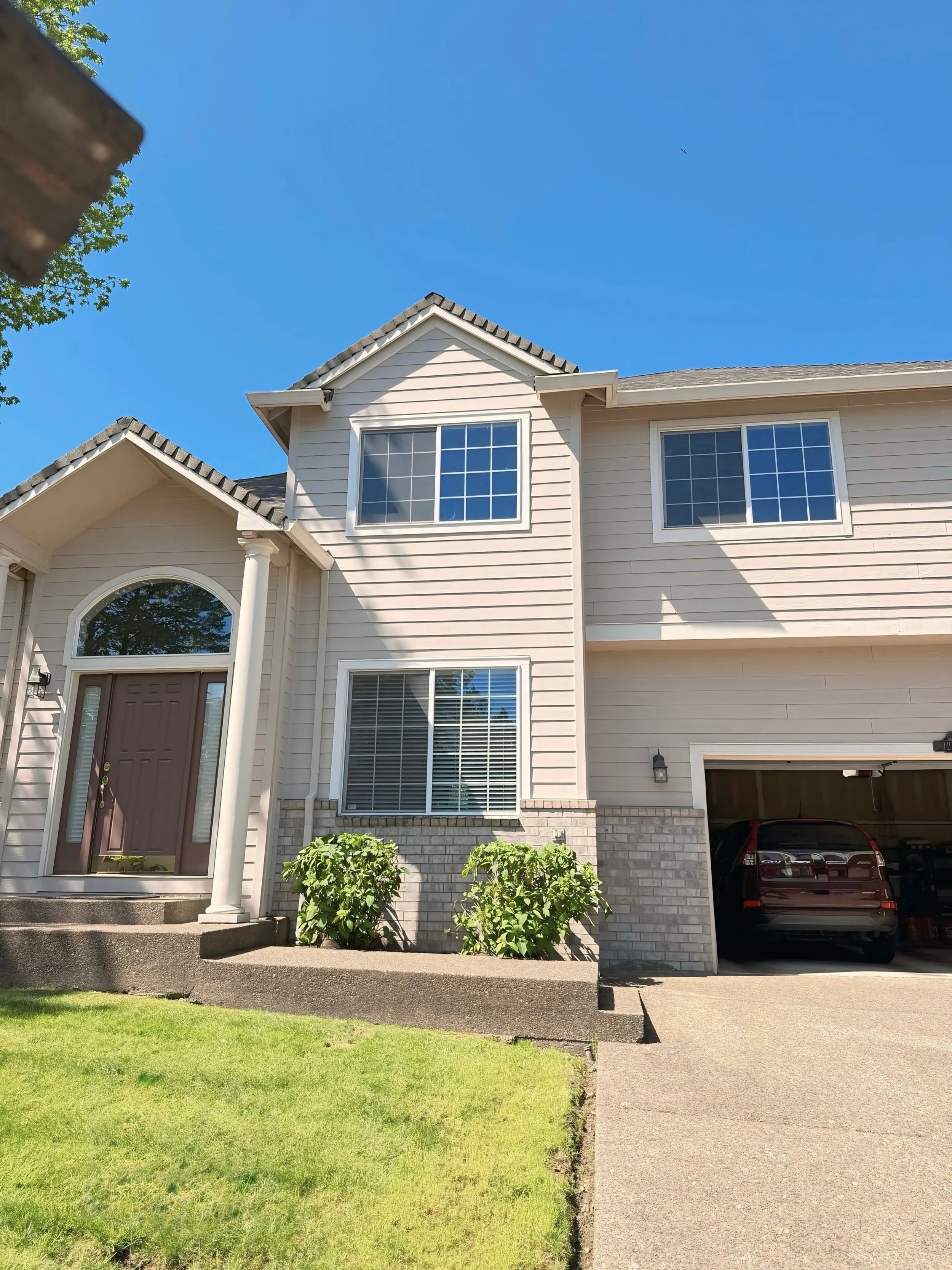 Two-story Westside Portland home with freshly painted white siding and brown front door by Cascade Painting