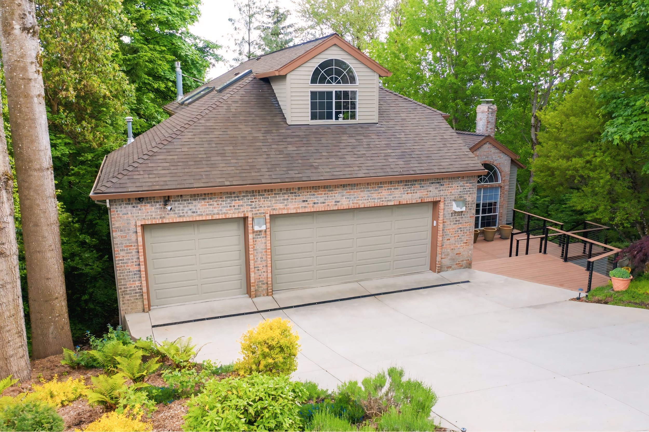 Brick exterior home with painted trim and refreshed garage doors, Westside Portland project by Cascade Painting