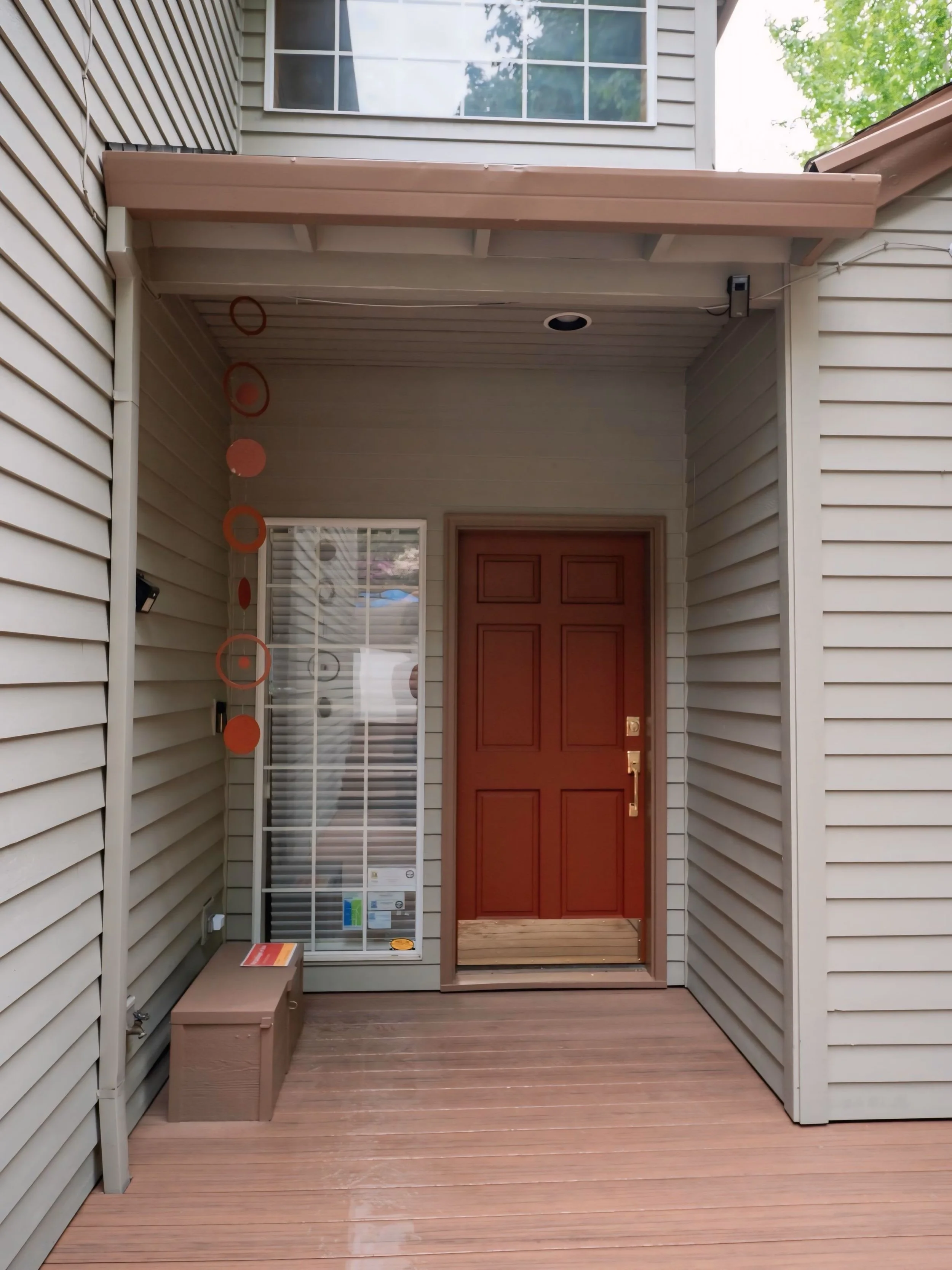 Freshly painted front porch with brown door and vinyl siding, exterior trim work by Cascade Painting in Beaverton OR