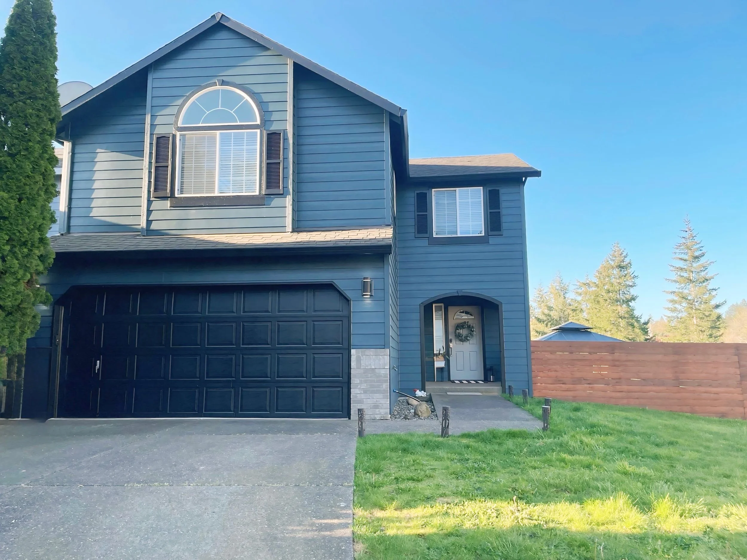 Freshly painted two-story blue home in Beaverton with new exterior color, residential painting project by Cascade Painting
