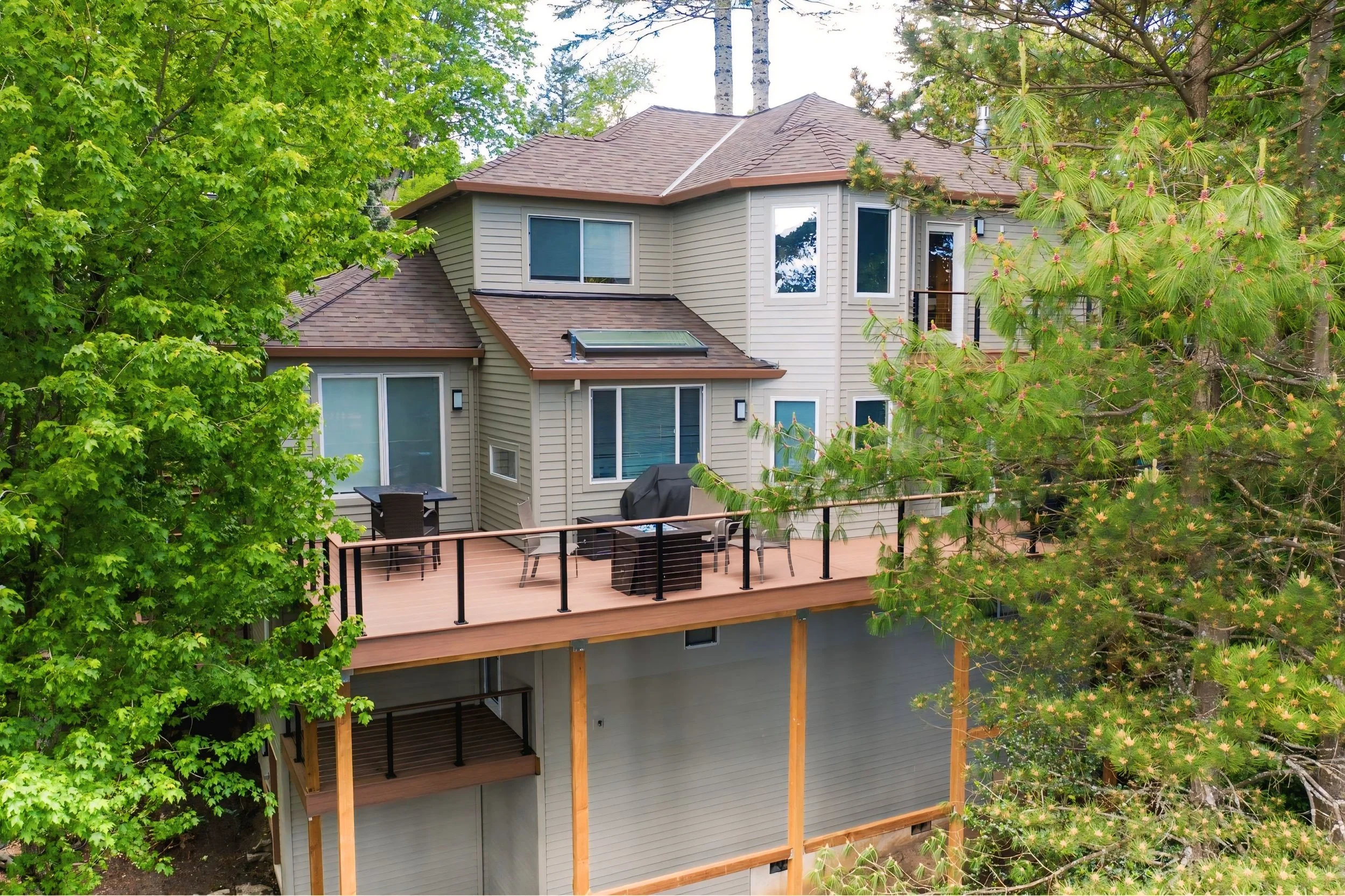 Modern Beaverton home with newly painted beige siding and a stained wooden deck, exterior painting by Cascade Painting