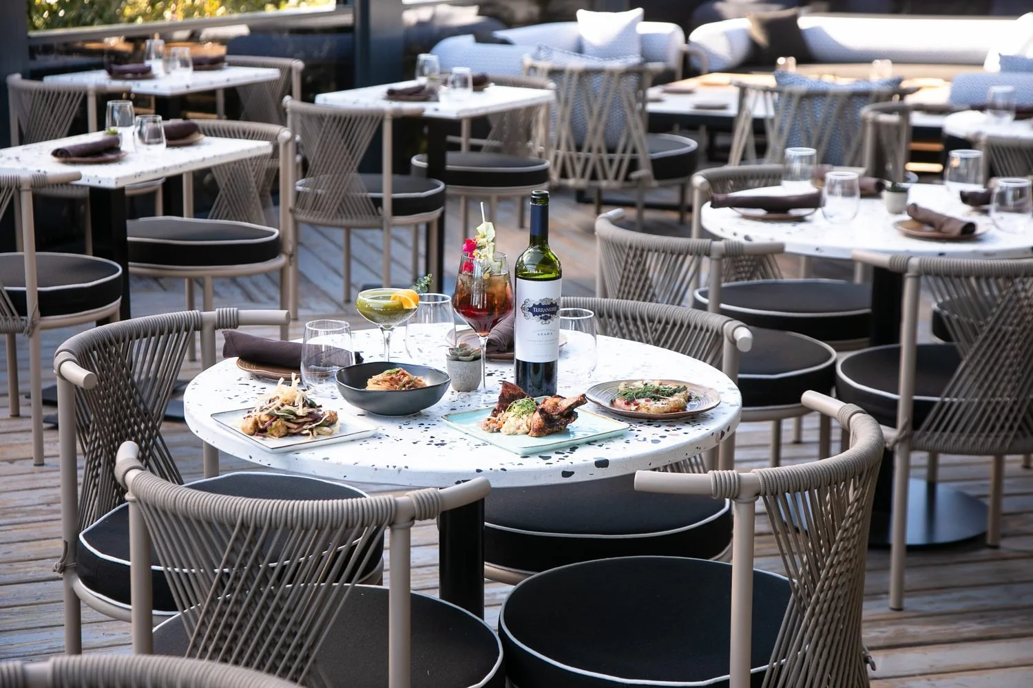 Table of shared plates and wine on the patio at an Atlanta restaurant