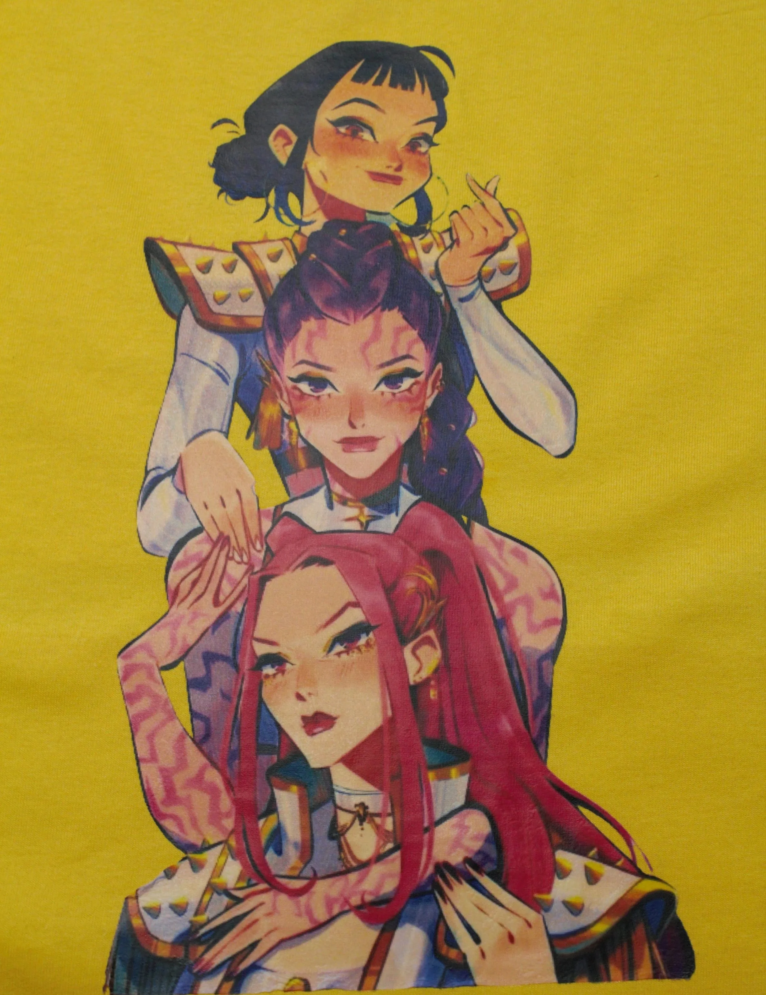 Illustration of three women from K-Pop demon hunters with various hair colors and styles, posing confidently against a yellow background.