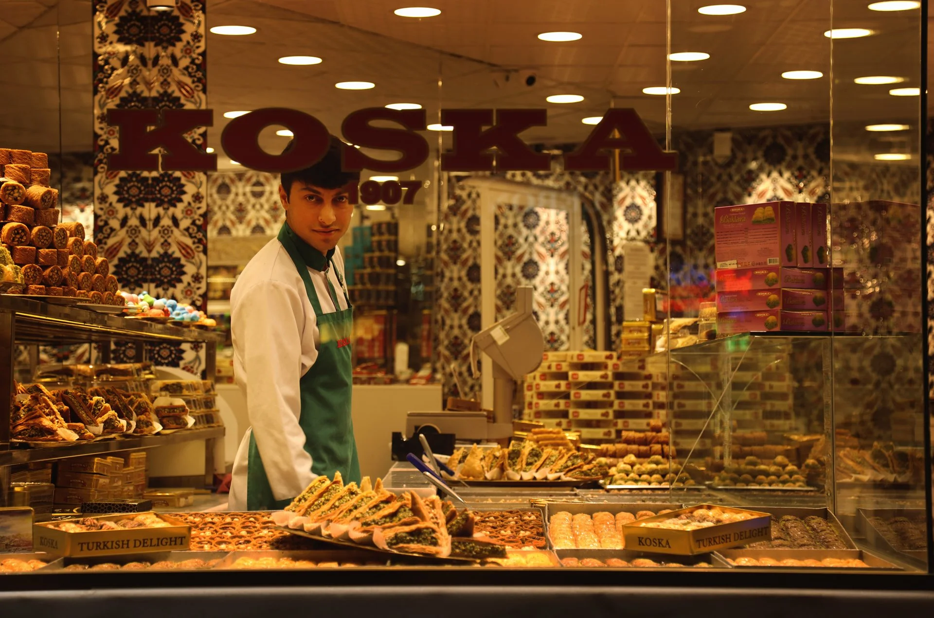 Portrait of a young man standing on the confectionery store, looking at camera, Istiklal Street, Turkey