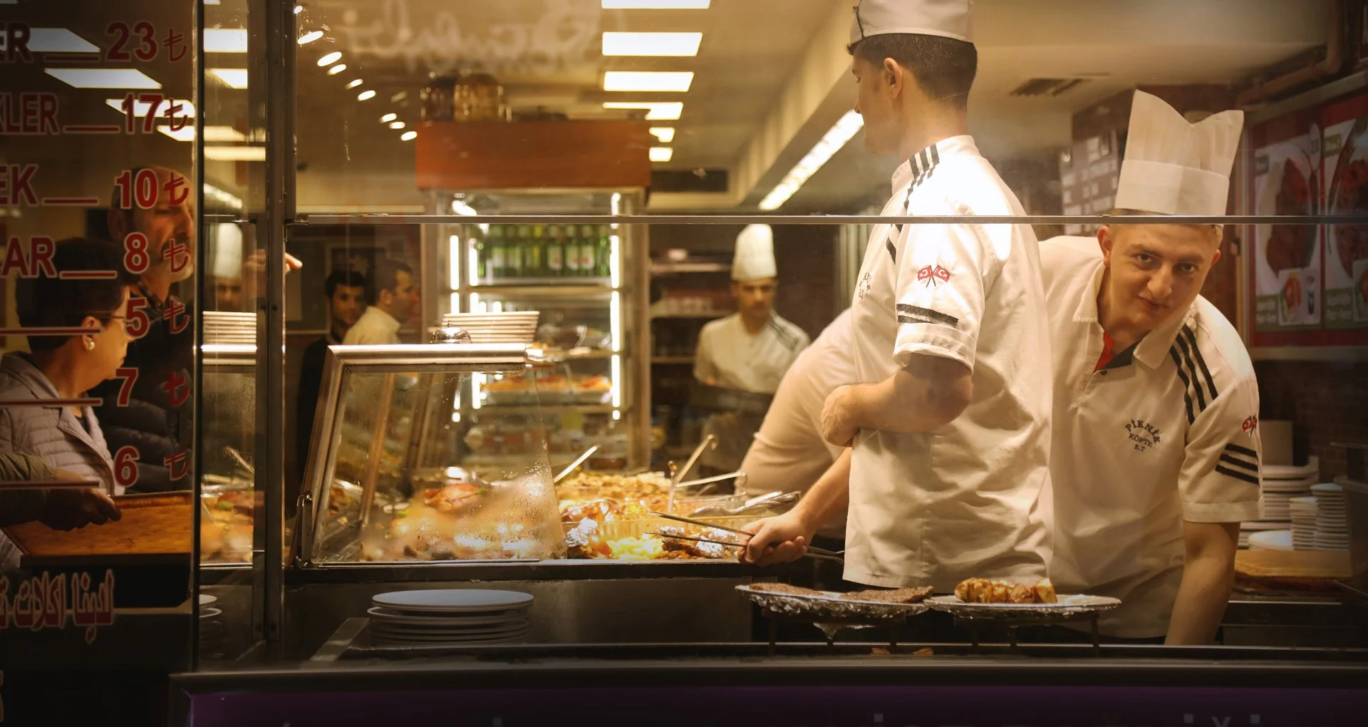 A young man standing in the restaurant, looking at the camera and smiling, Istiklal Street, Turkey