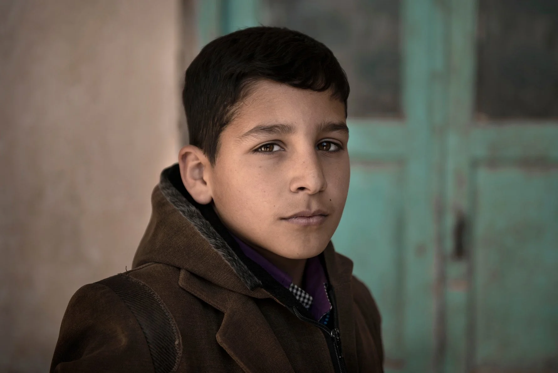 Close-up portrait of Iranian boy standing in the village house