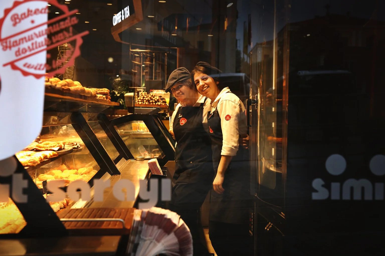 Portrait of a young girls standing in the confectionery store, looking at camera and smile, Istiklal Street, Turkey