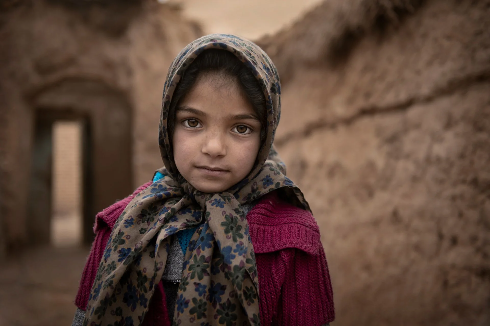 Portrait of Iranian little girl standing in the village house 