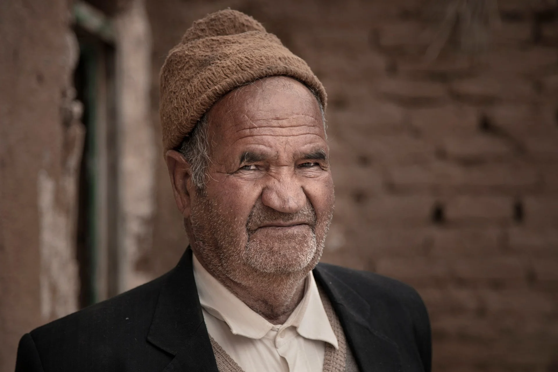 Portrait of an old man standing in the village house, Yazd, Iran.