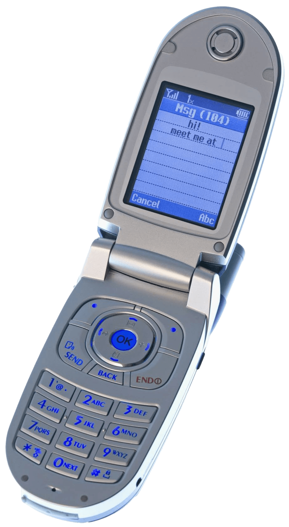 Close-up of an old flip phone with a text message on the screen that says 'hi meet me at 1' and options to cancel or send.