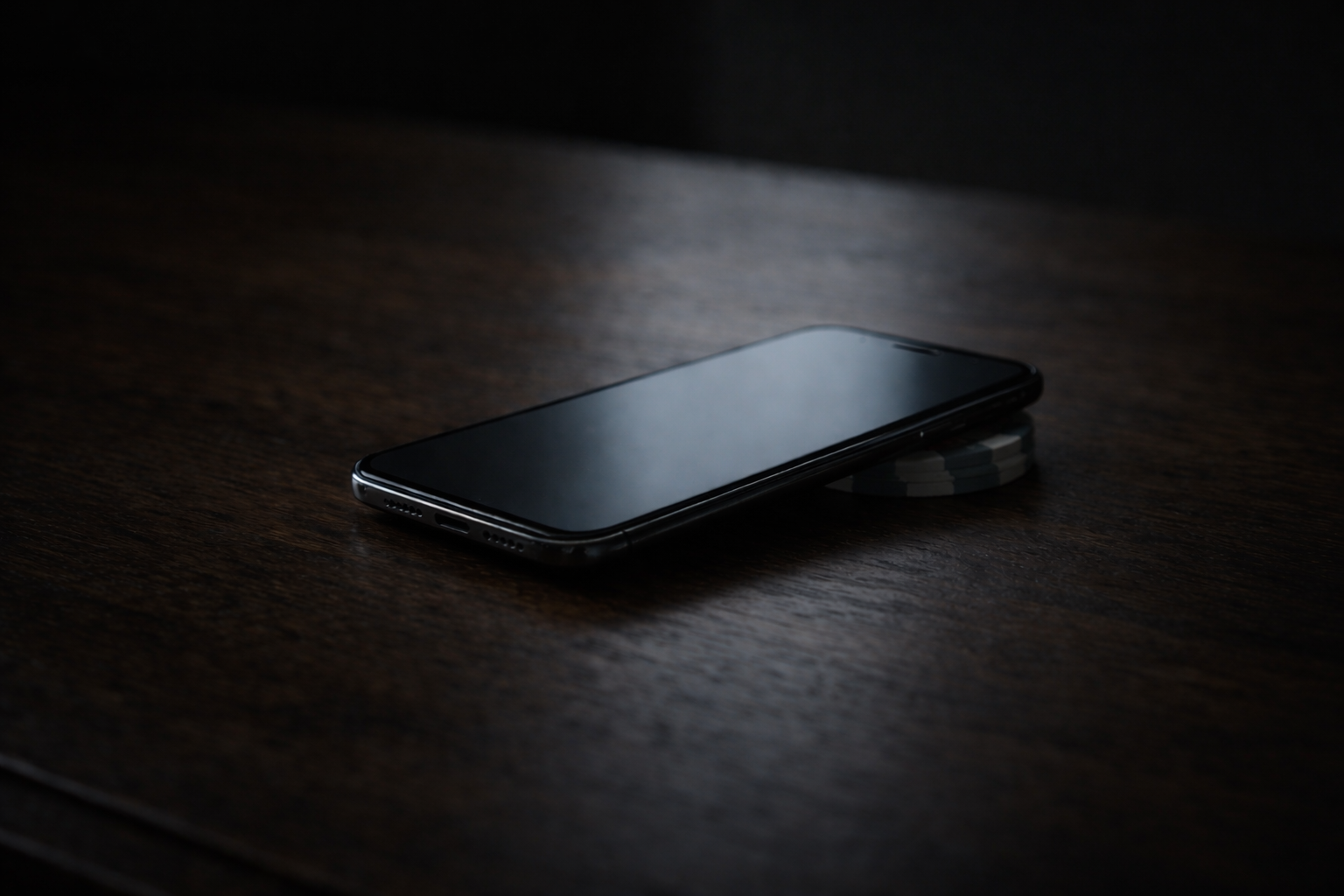 Smartphone resting on poker chips on a dark wooden surface. Symbolic image representing gambling disorder, a recognized behavioral addiction treated at Lazar Clinical.