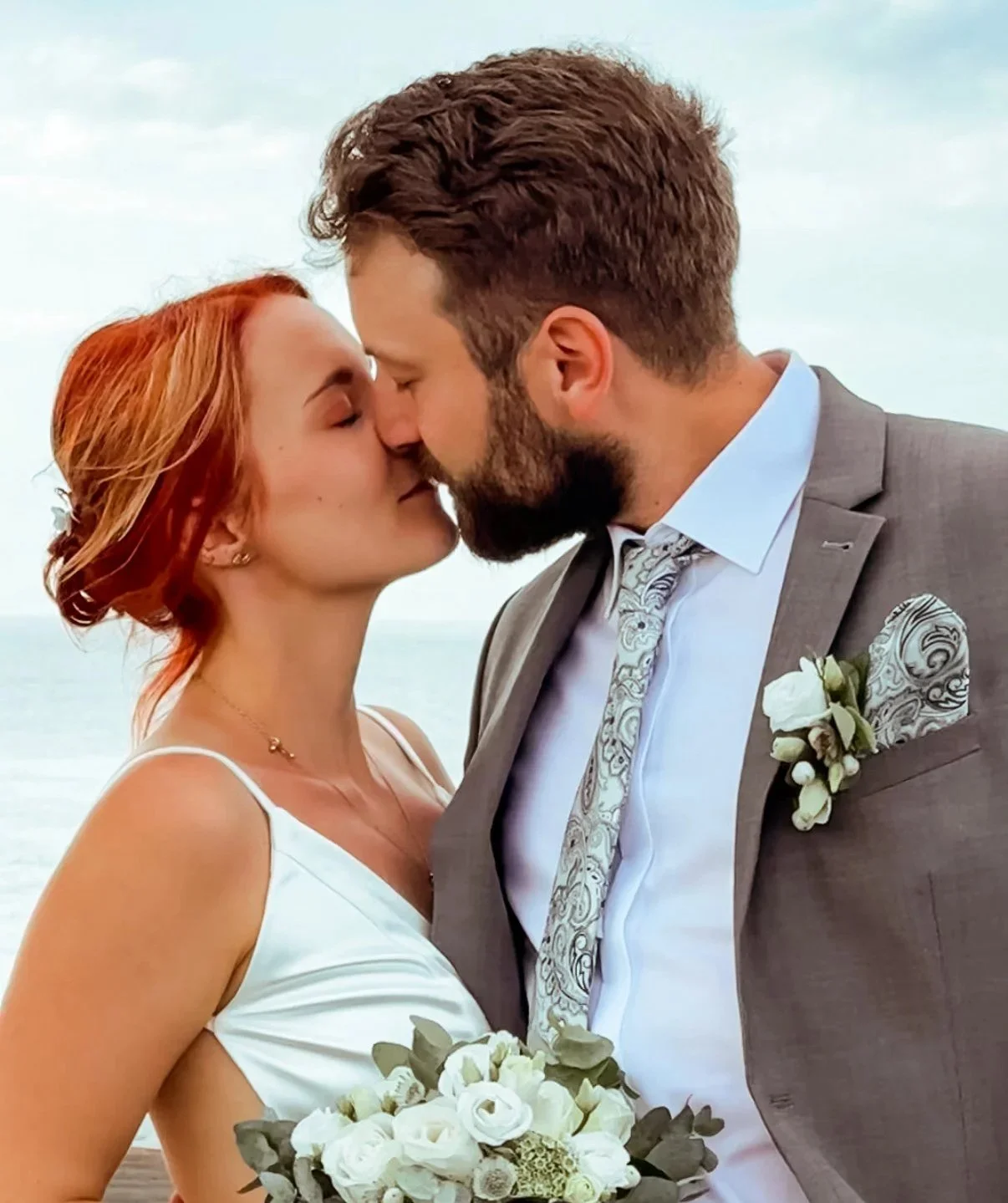 Brautpaar küsst sich bei der Hochzeit am Strand