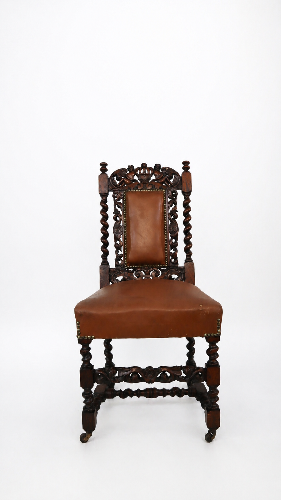 A vintage wooden chair with intricate carvings and brown leather upholstery, set against a plain white background.