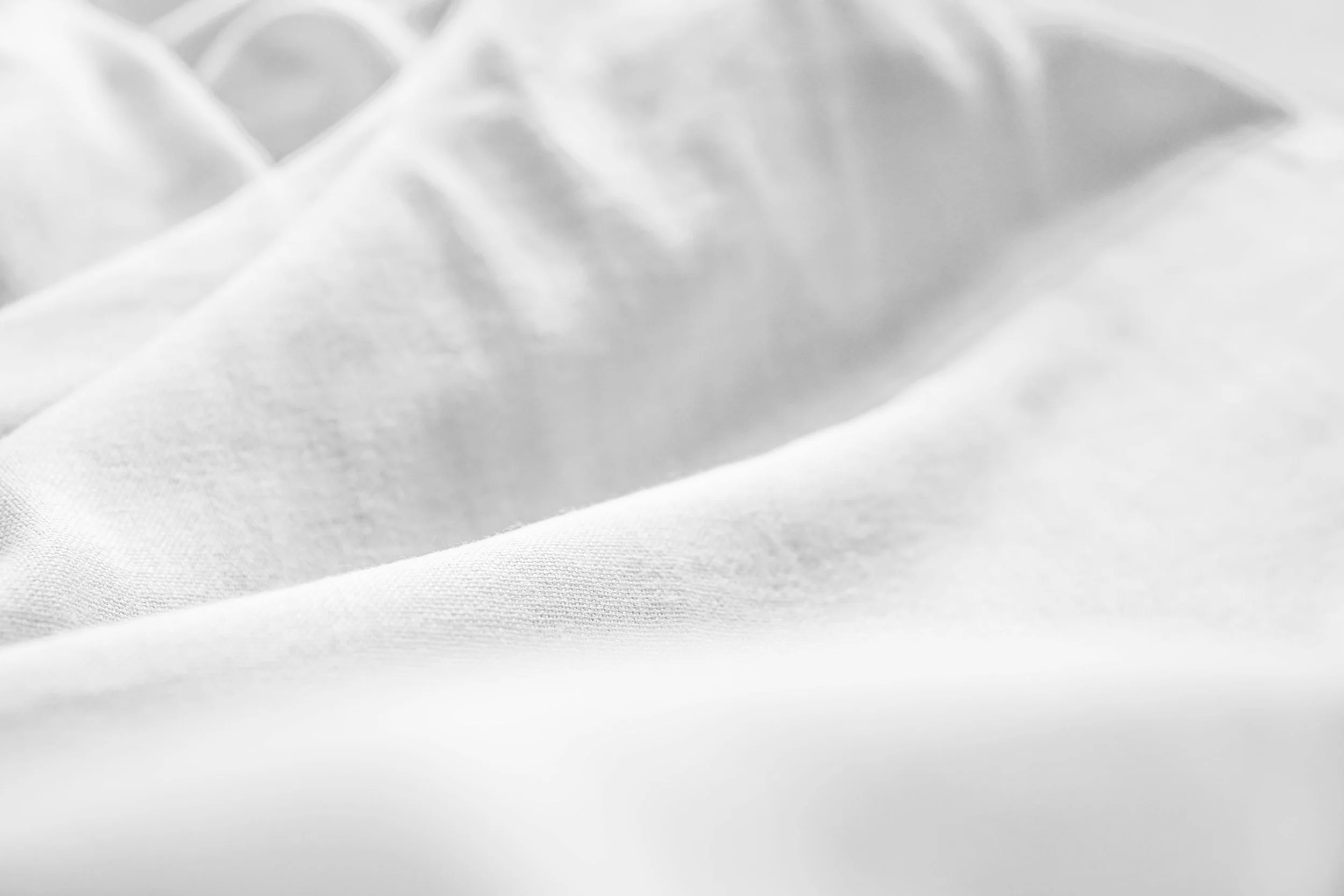 Close-up of a soft, white, folded fabric.