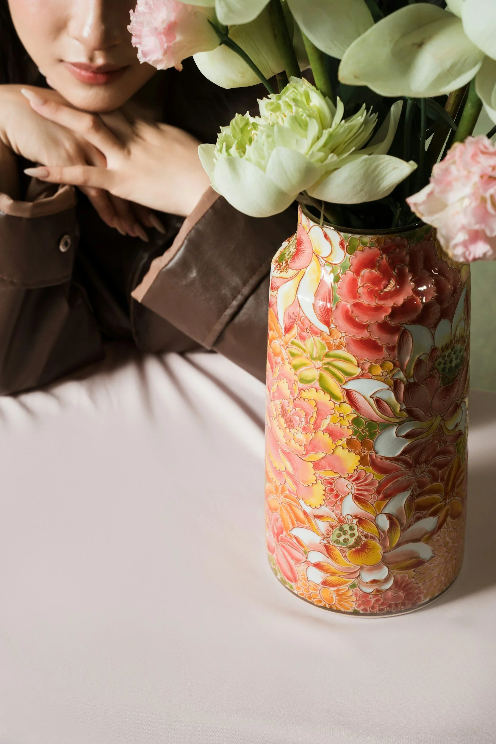 Vase with patterned floral design, filled with white and pink flowers.