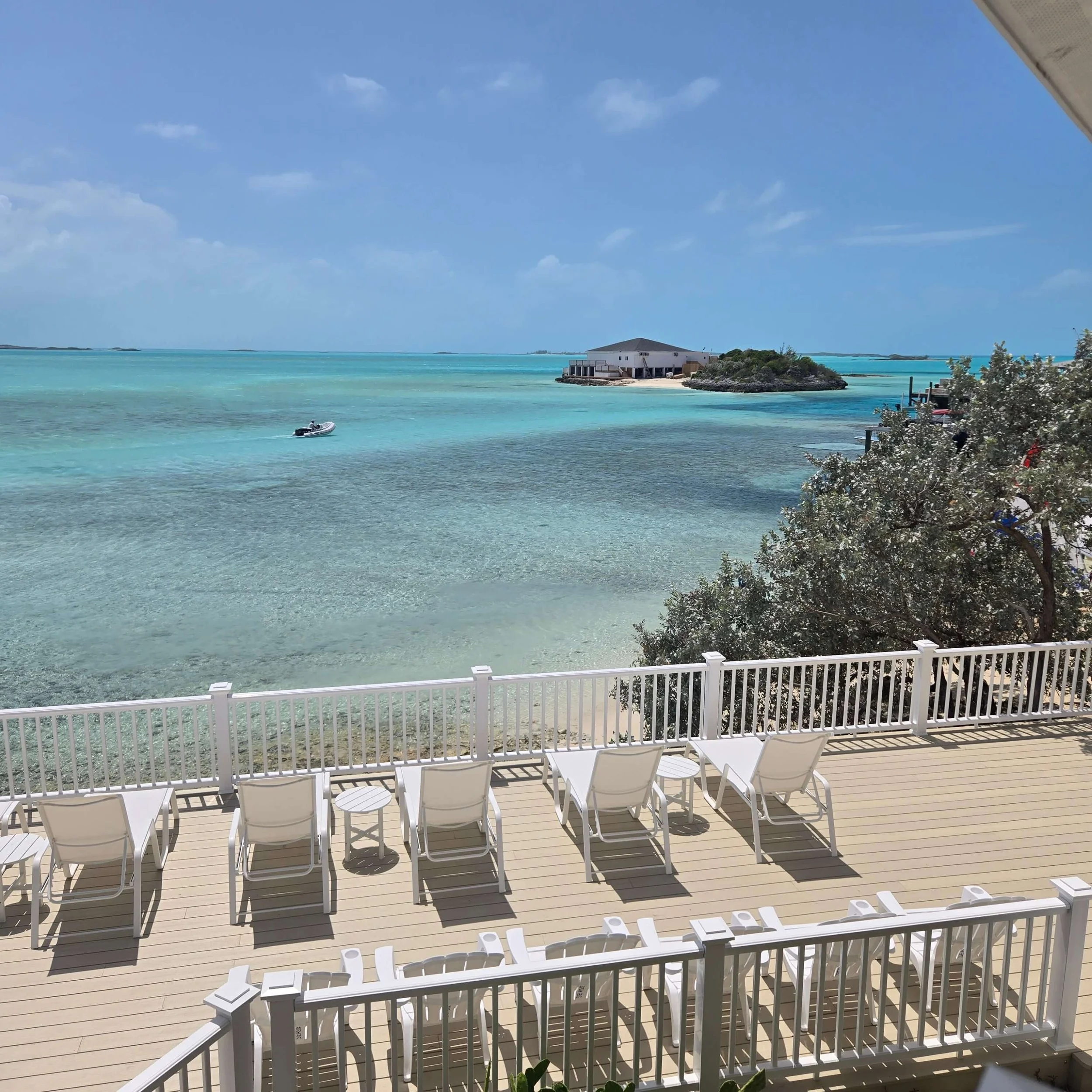 Oceanfront sundeck with lounge chairs at Seaside Staniel Cay