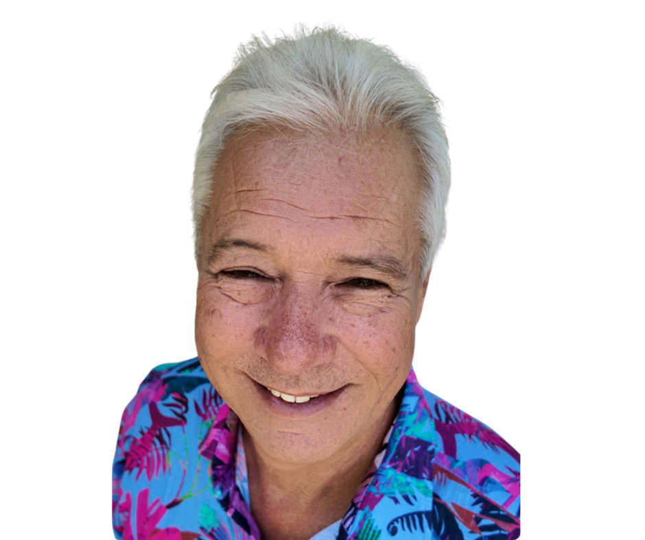 A smiling older man with gray hair wearing a colorful Hawaiian shirt.