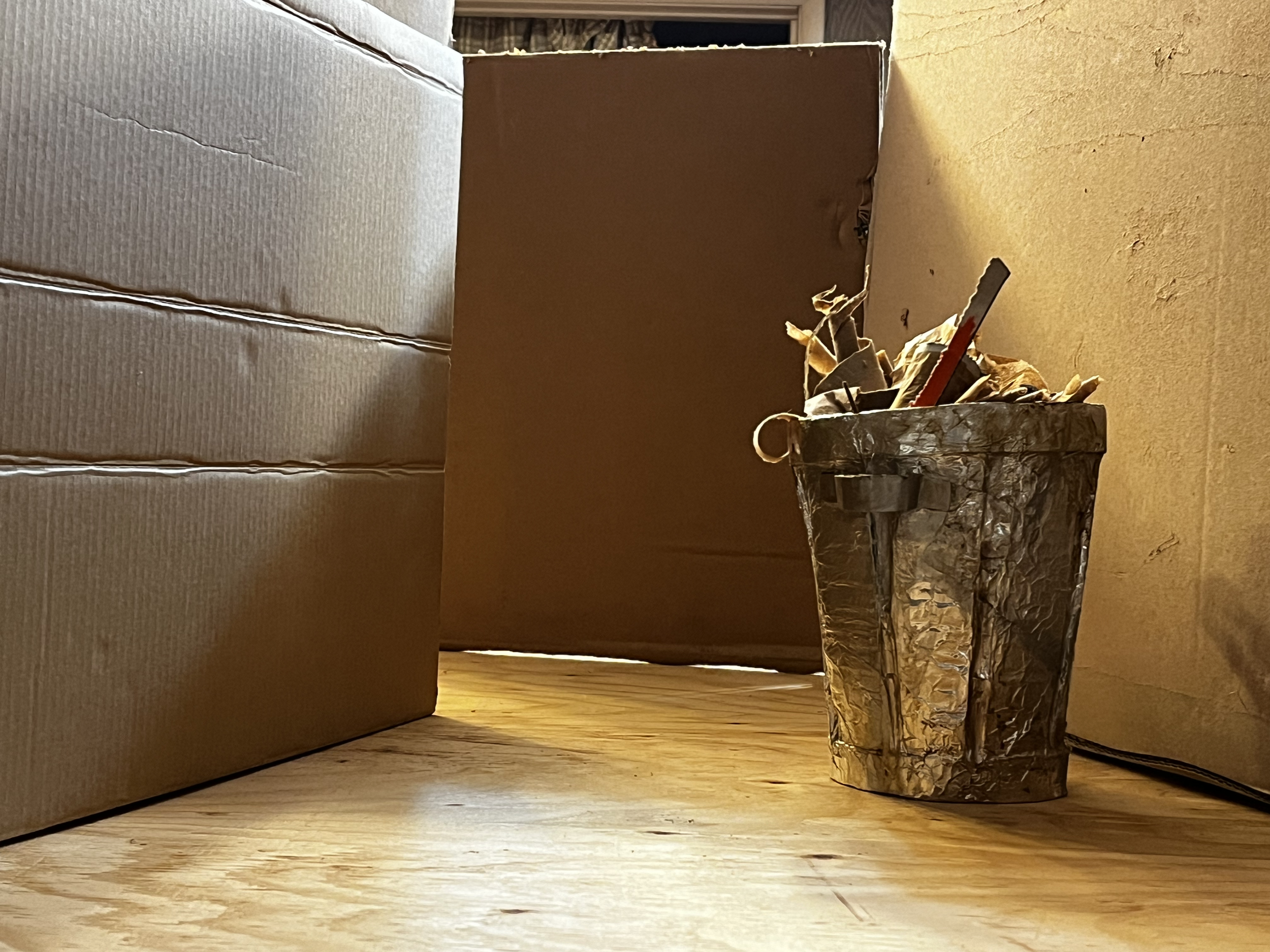 Alleyway built of cardboard, before lighting. Trashcan also cardboard.