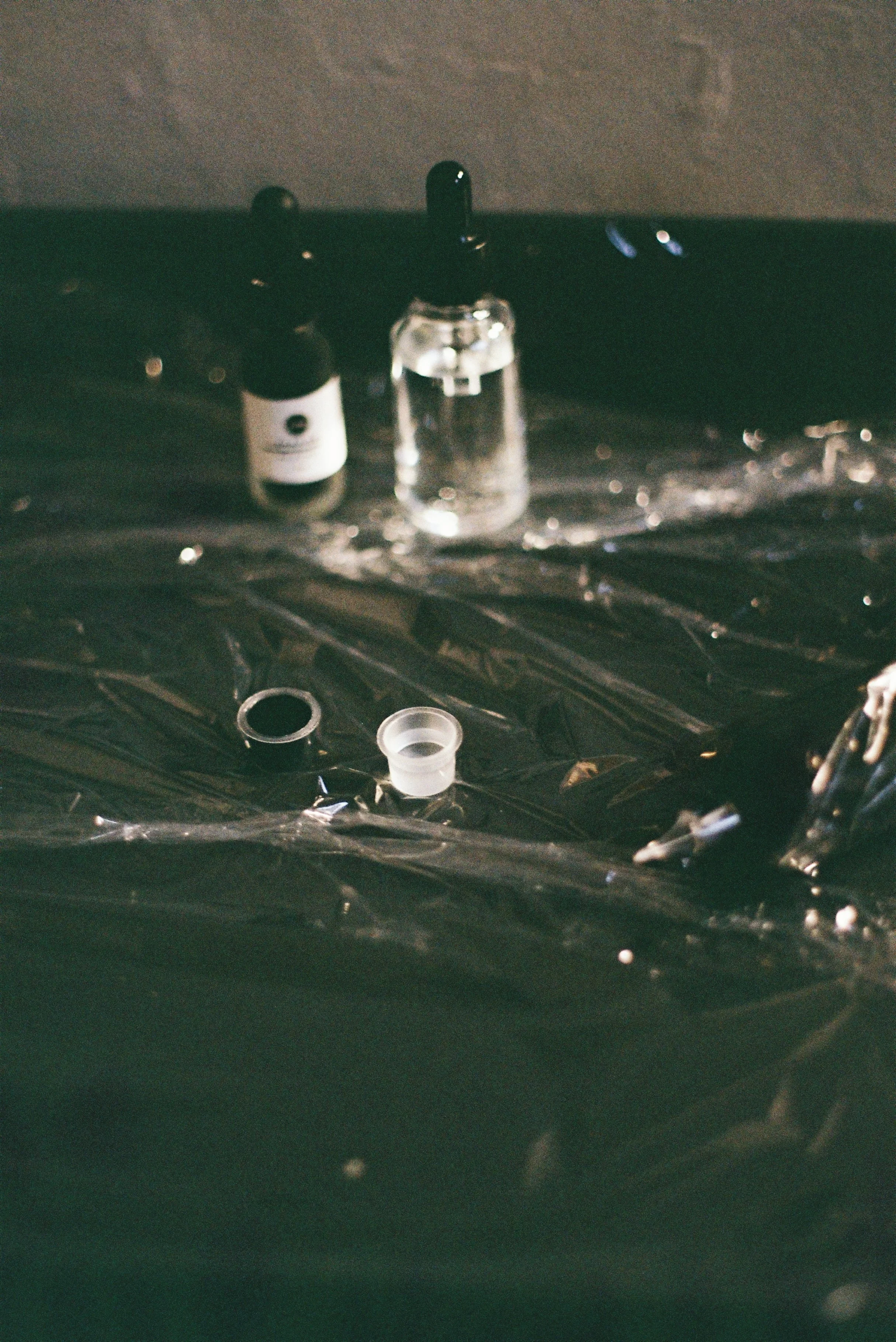 Various small bottles and lid/container parts on a black surface.