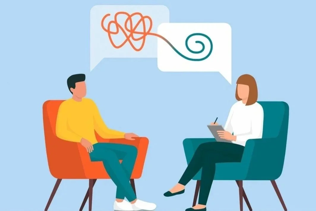 A person in a yellow shirt speaks with a therapist or counselor, who is taking notes on a tablet during a therapy session. The conversation is depicted with speech bubbles containing abstract squiggly lines.