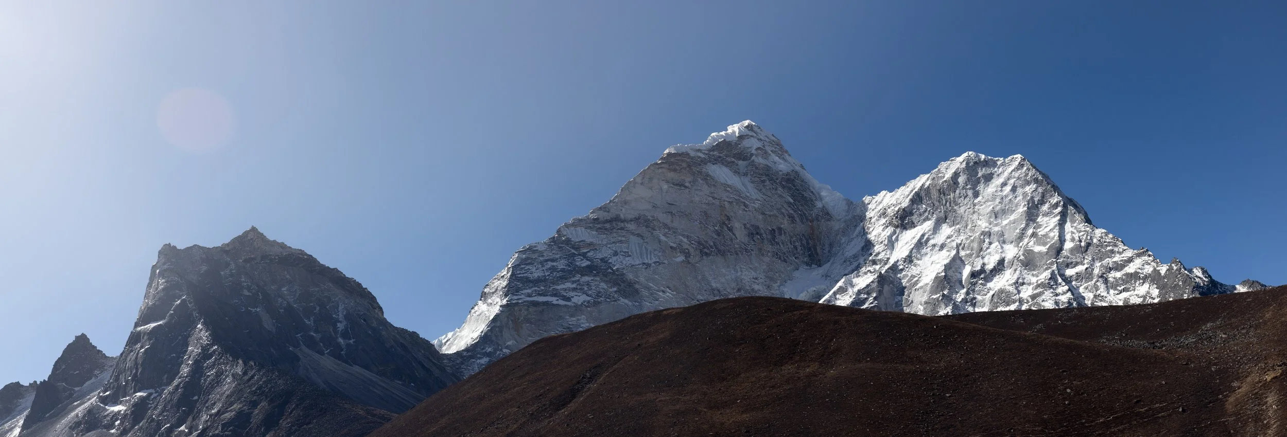 Snow-covered mountain peaks against a clear blue sky.
