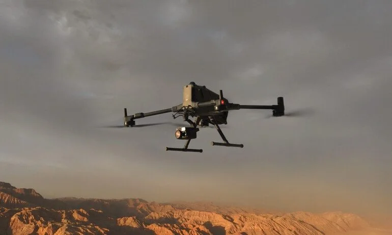 Un drone volante sopra un paesaggio desertico con montagne.