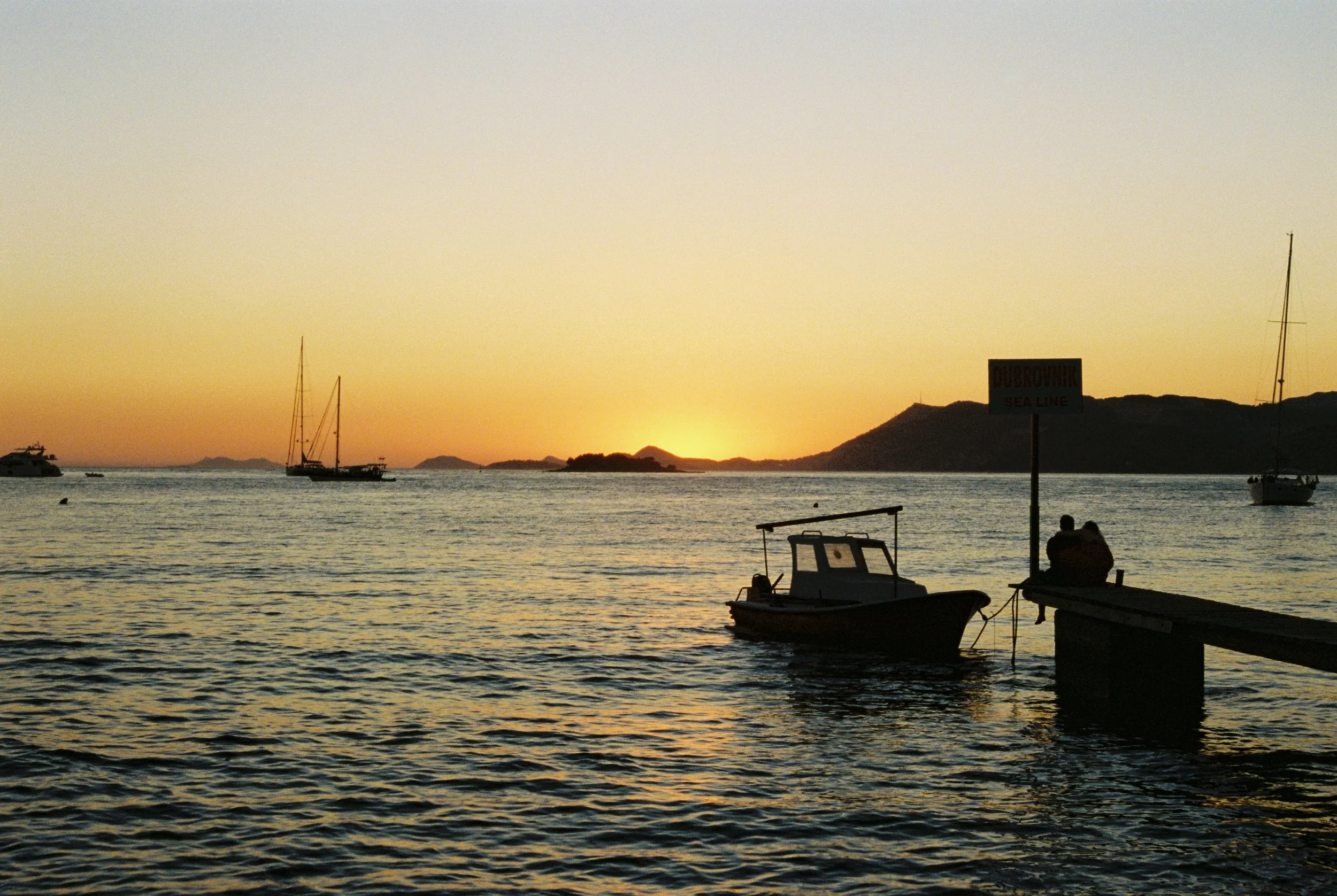 Boats floating on a calm sea during sunset in Cavtat, Croatia. 