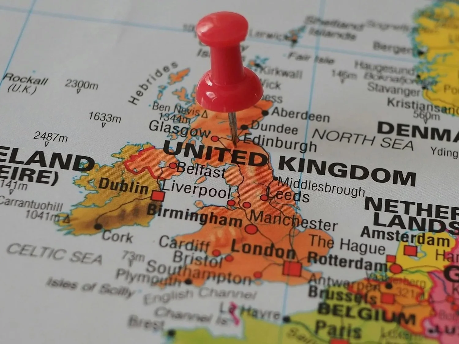 A map of Europe with a red pushpin marking the United Kingdom.