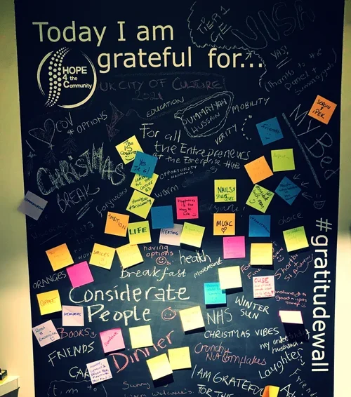 A blackboard with the message 'Today I am grateful for...' and various handwritten notes, doodles, and colorful sticky notes expressing gratitude for things like friends, health, family, country, music, Christmas vibes, and more.