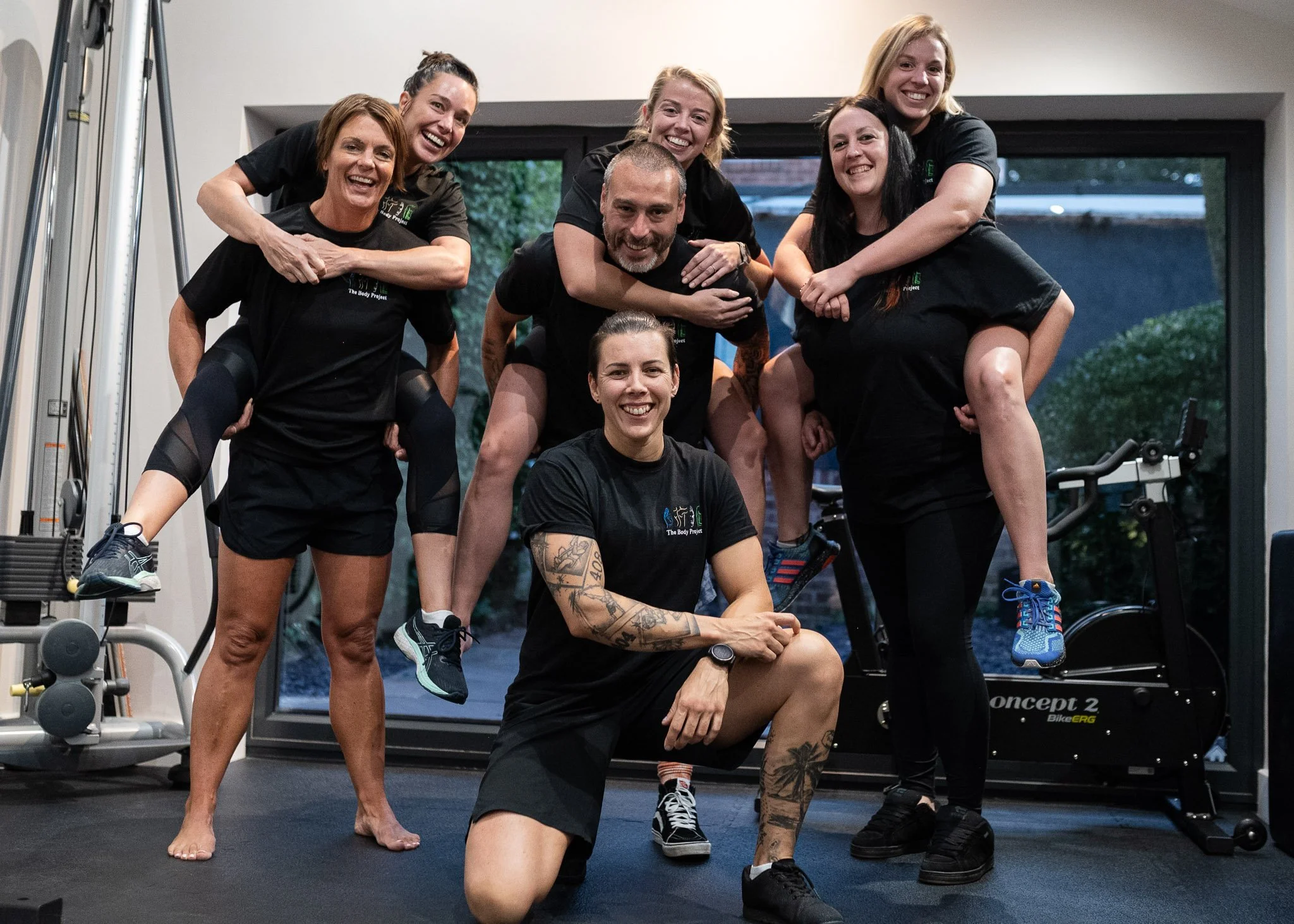 The body project team stand as a group in the clinic gym smiling