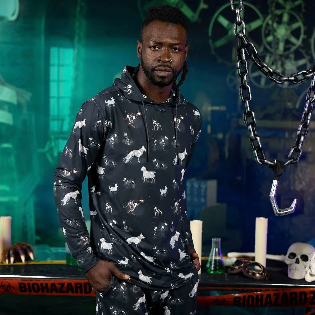 Model wearing a dark hoodie printed with Lee Gruber’s repeating skeleton-dog pattern