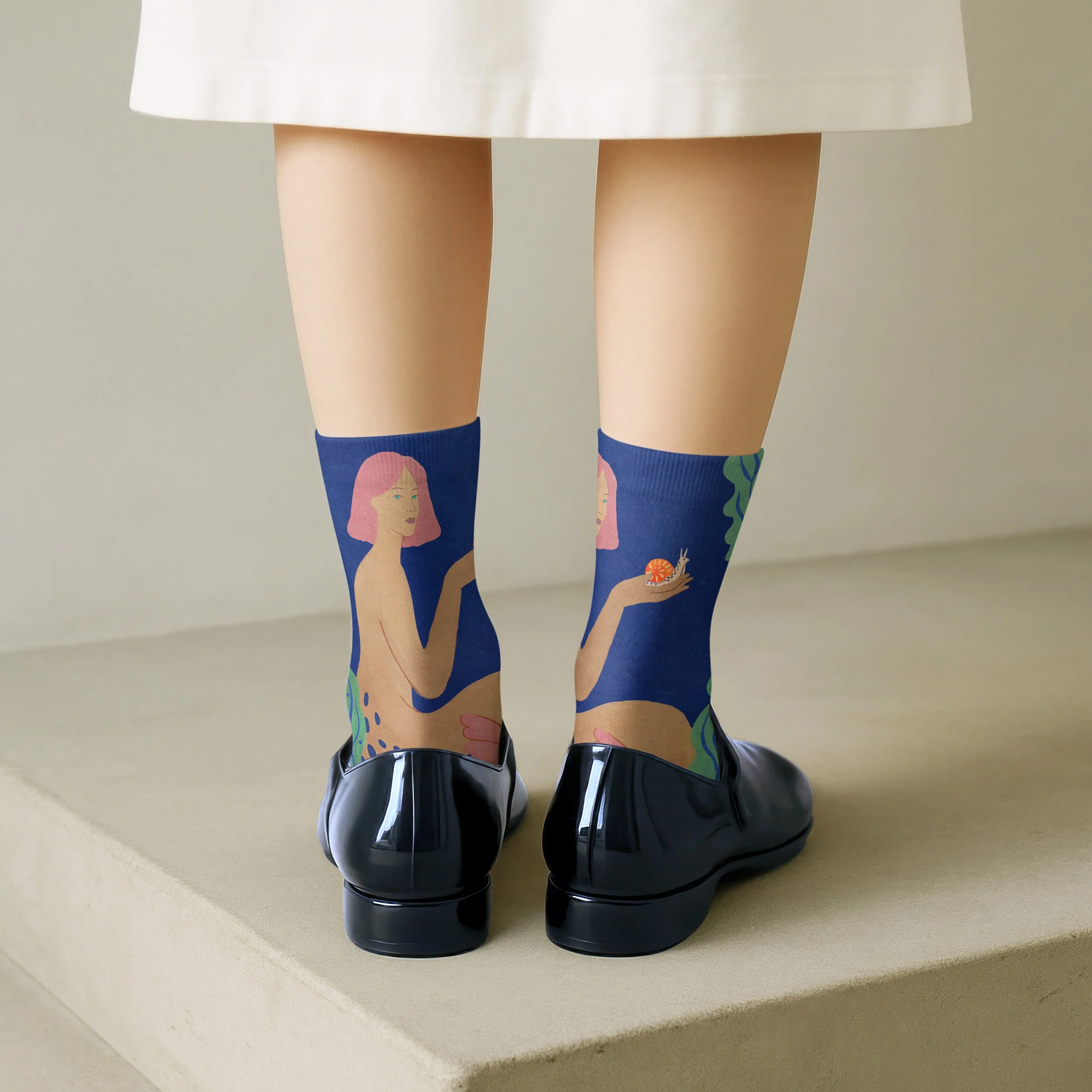 Resist Speed illustrated socks featuring a woman holding a snail