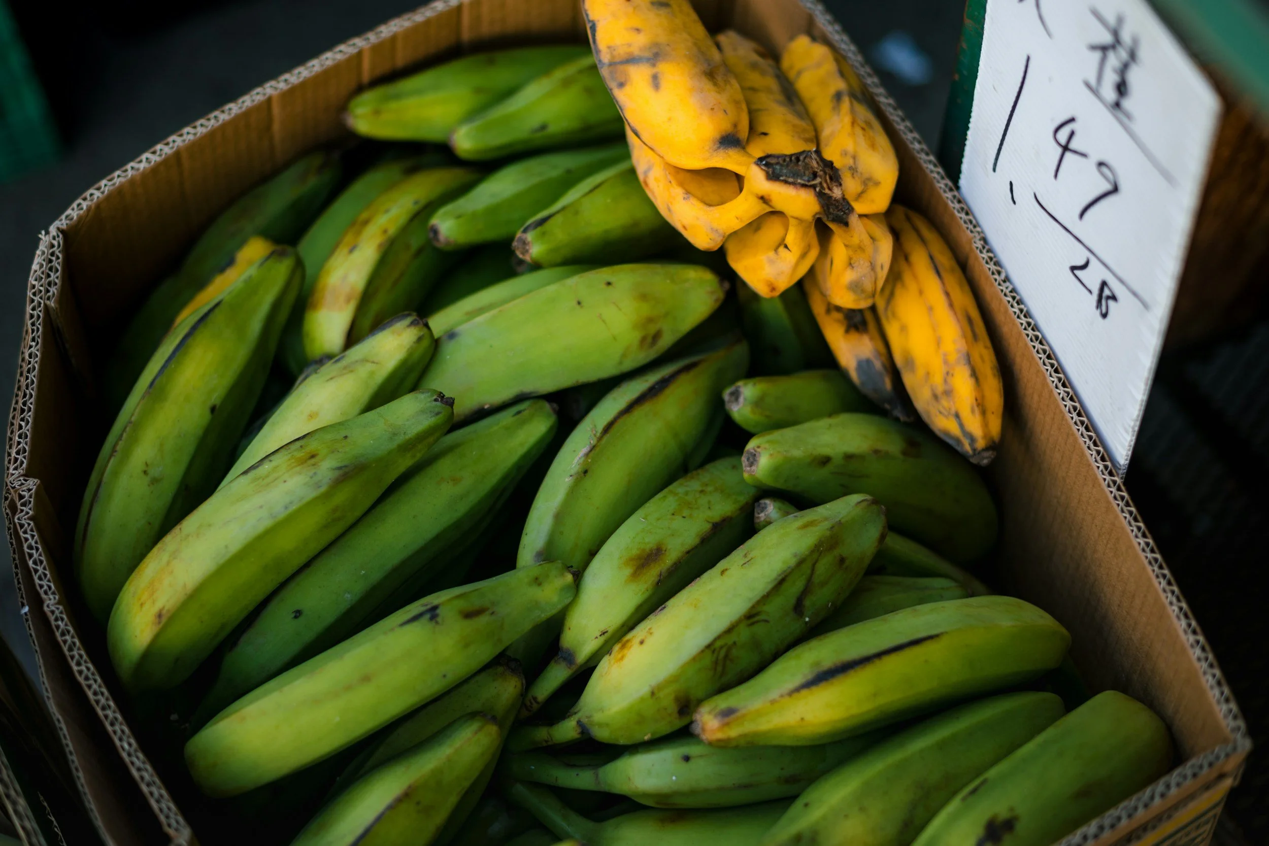 Eine Kiste voll mit grünen und gelben Plantain