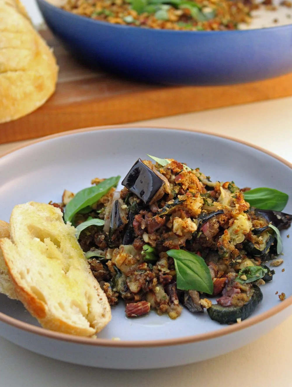 Italian Summer Vegetable Gratin with roasted zucchini, eggplant, kalamata olives, and a crisp lemon-almond pangrattato, served with homemade garlic bread.