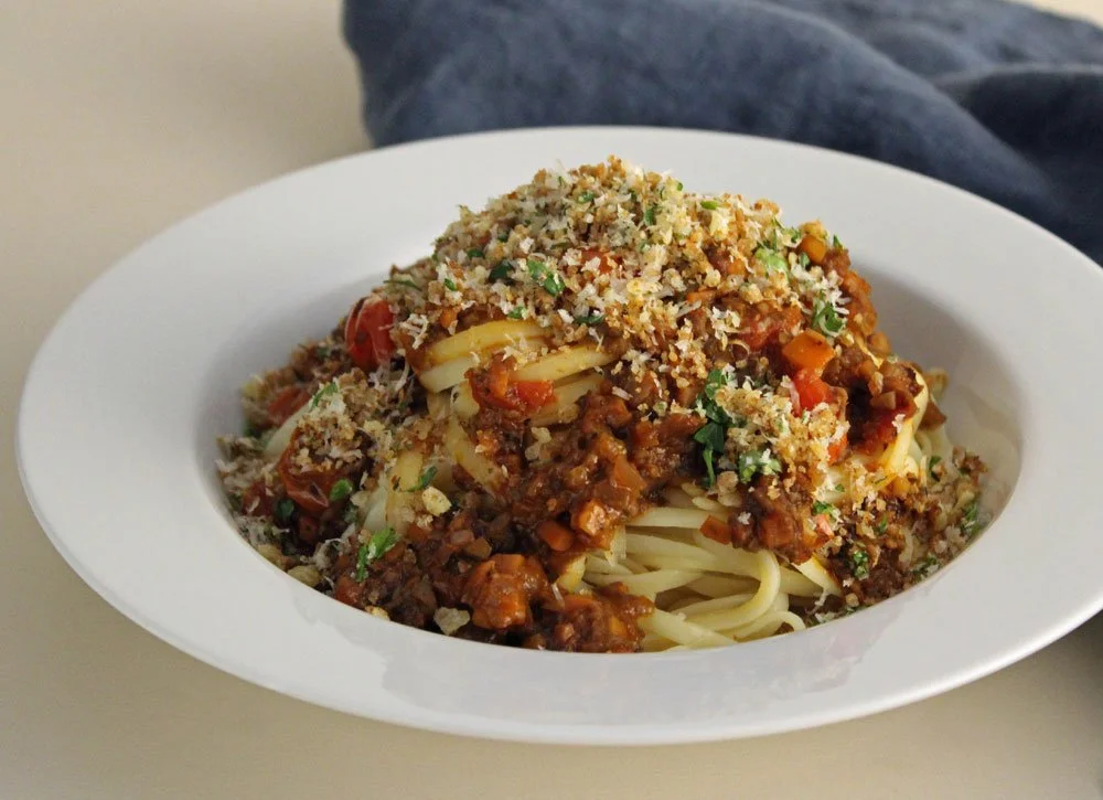 Autumn Market Ragù served over spaghetti with roasted tomatoes, fresh herbs and a crisp toasted breadcrumb topping.