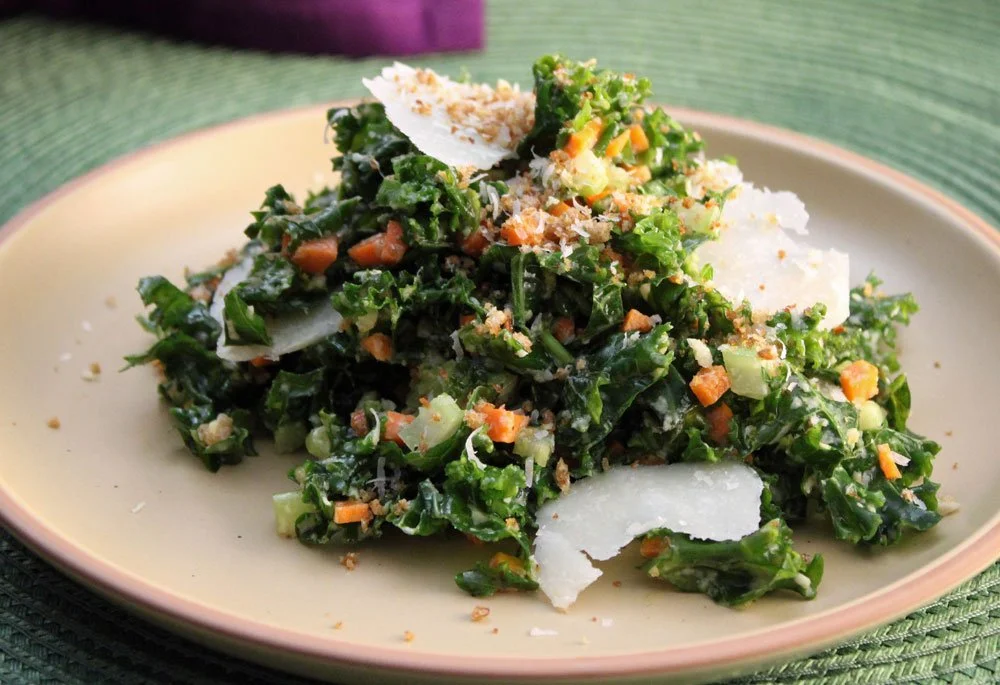 Fresh kale salad topped with Parmesan shavings, crunchy breadcrumbs, carrot, and celery in a light creamy dressing.