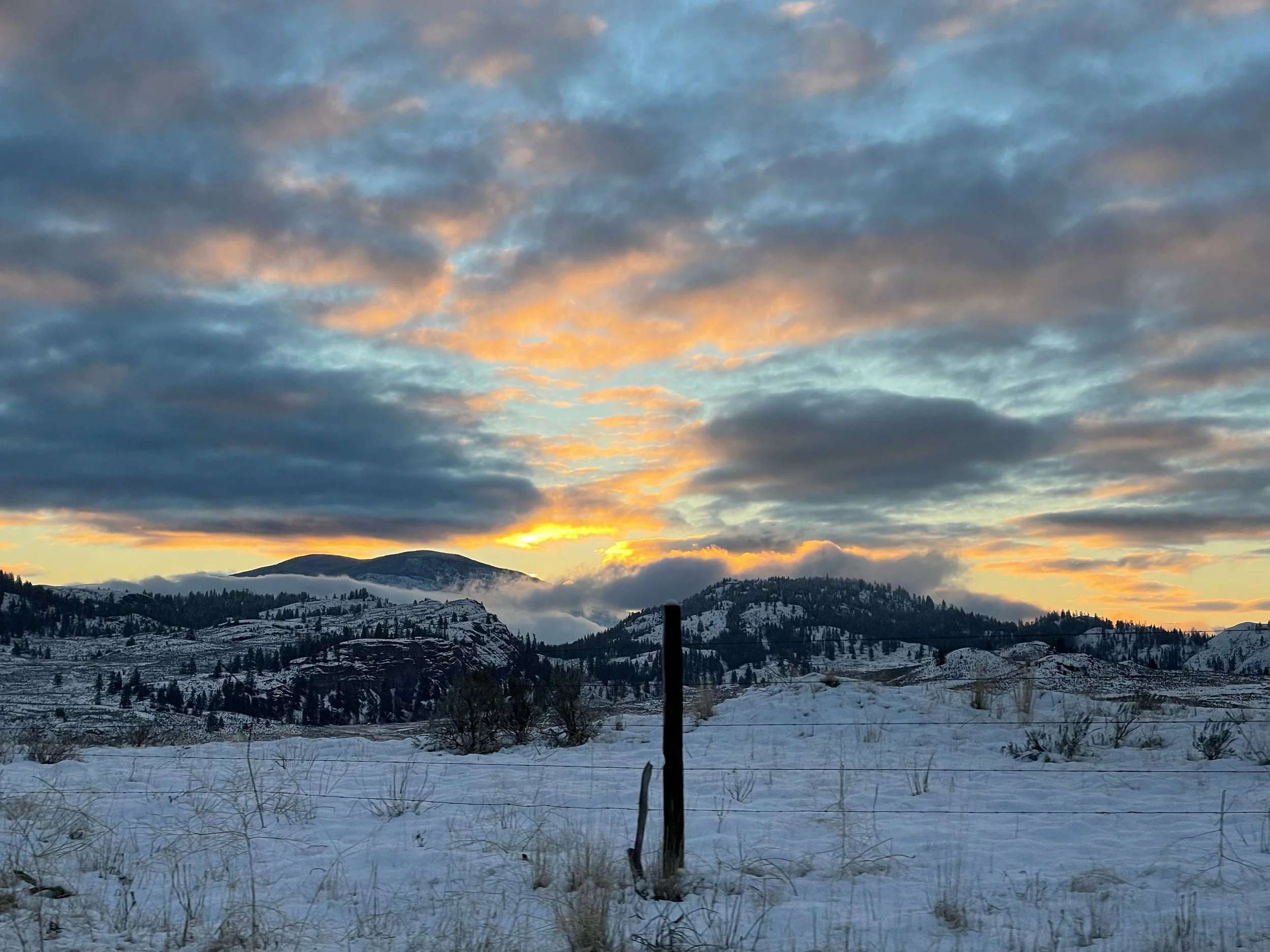 Snowy Okanagan meadow with fiery orange sunrise