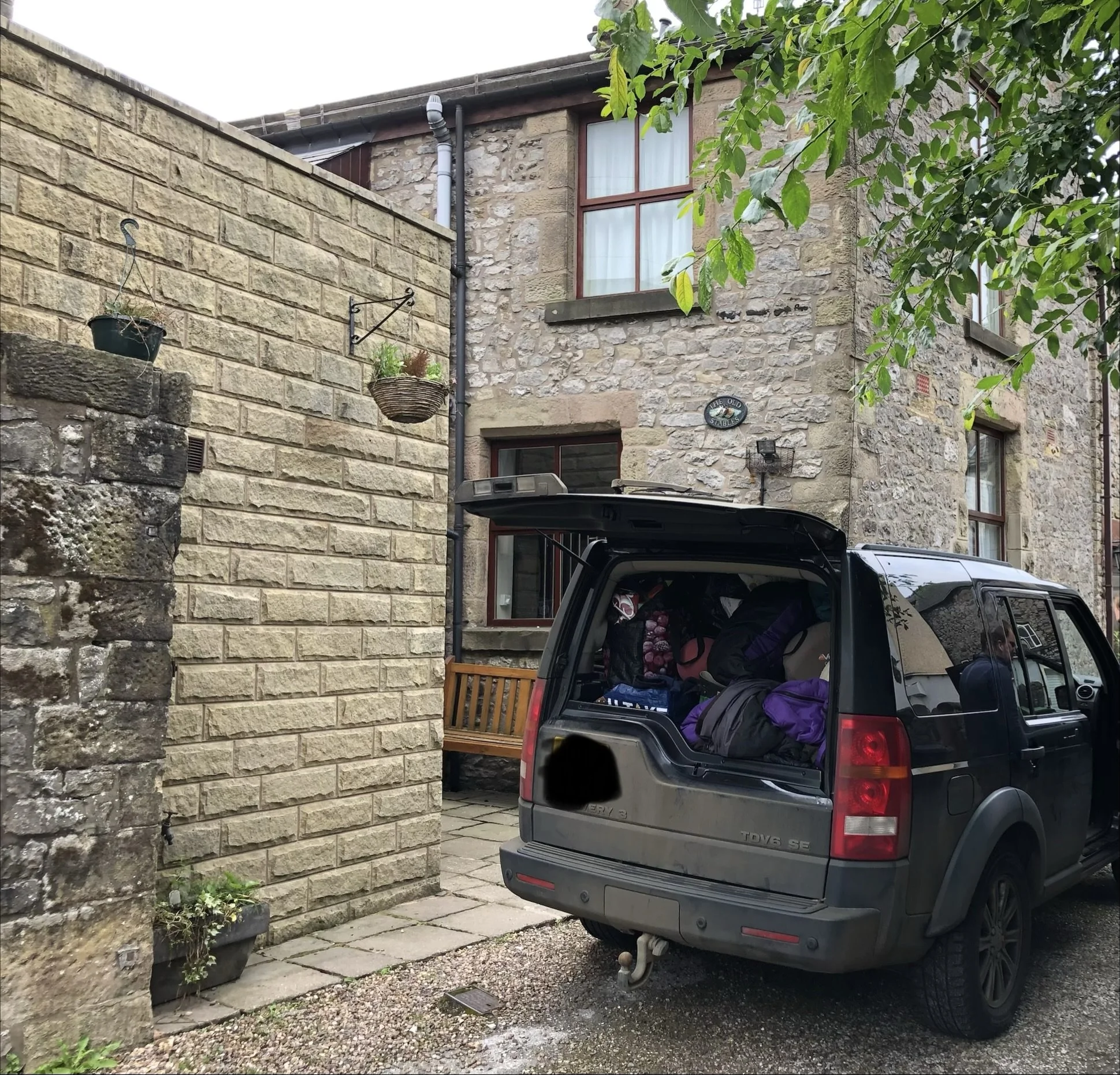 A Land Rover parked outside a large holiday home in central Buxton, showing easy access for unloading luggage and outdoor gear for a group of 10.