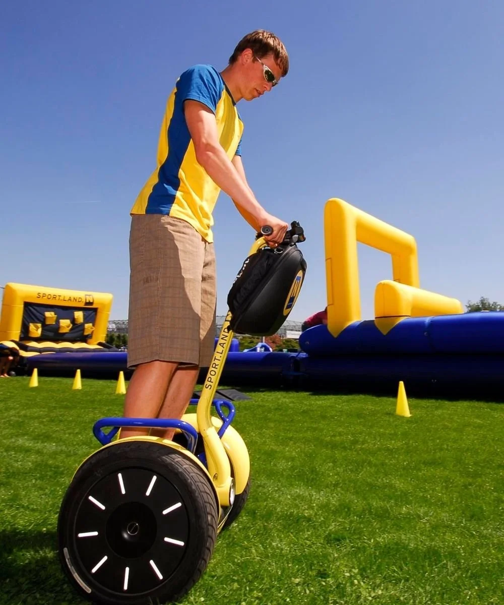 Ein junger Mann absolviert mit einem gelb-schwarzen Segway einen Geschicklichkeitsparcours beim Bewegungstag von SPORTLAND Niederösterreich bei den LADIES OPEN Amstetten.