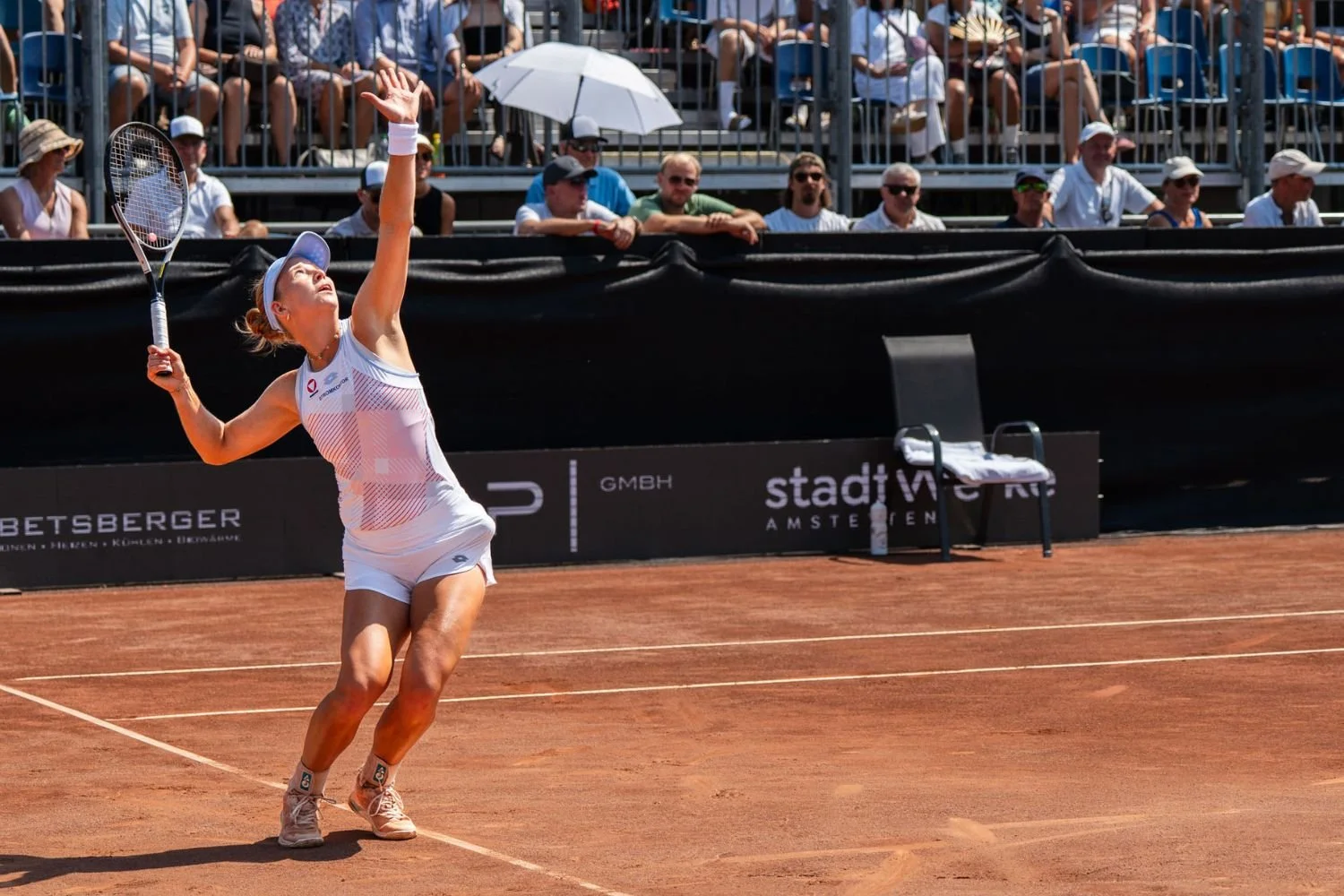 Sinja Kraus wird bei einem Aufschlag am Center Court vom Publikum auf der Tribüne beobachtet.