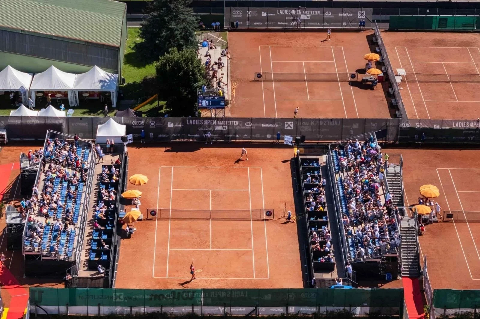 Luftaufnahme von  Center Court mit gefüllten Tribünen und Court 1 im Tenniszentrum der LADIES OPEN Amstetten.