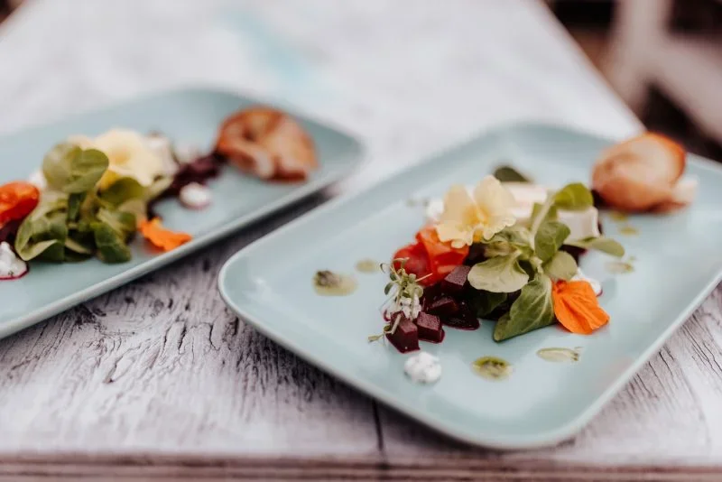 Zwei moderne blaue Teller mit Salat und Blätterteiggebäck im VIP-Club.